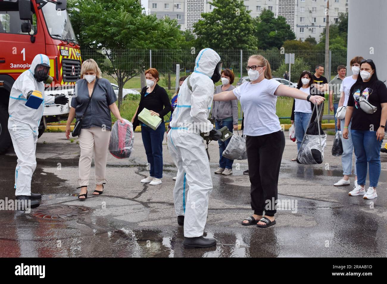 29 juin 2023, Zaporizhjhia, Ukraine: Les médecins portant des combinaisons de radioprotection vérifient le niveau de rayonnement des passagers d'un bus pendant la formation sur l'exposition aux rayonnements à Zaporizhjhia. Une formation spéciale de protection civile à grande échelle, proche des conditions réelles, a été organisée à Zaporizhzhia pour préparer une catastrophe possible à la centrale nucléaire de Zaporizhzhia. Les employés de l'Administration militaire de l'oblast de Zaporizhjia, des autorités locales, du Service d'urgence de l'État d'Ukraine, des membres des organismes d'application de la loi et des services spéciaux ont participé à la formation. Pendant la formation Banque D'Images