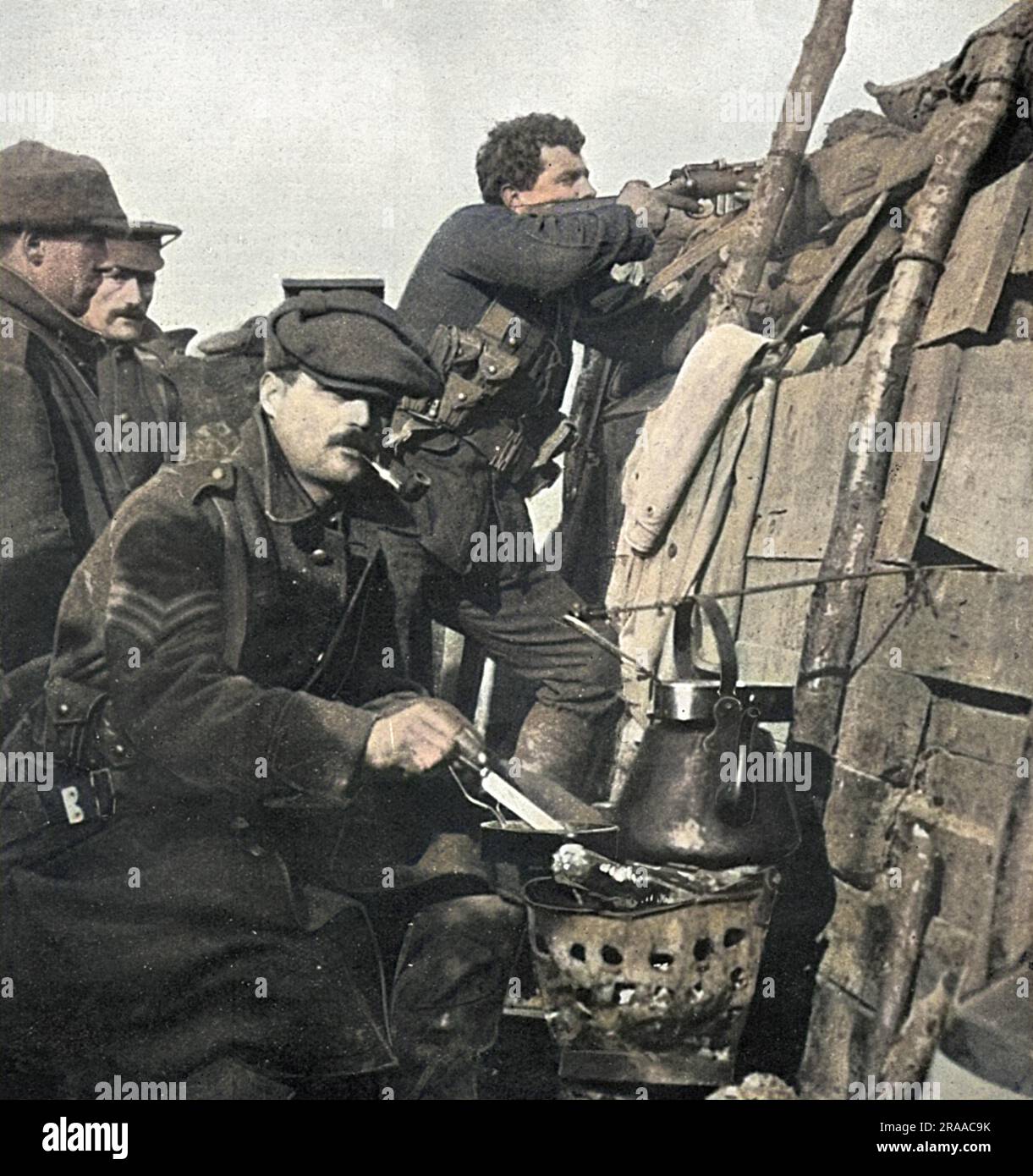 Quelque part en France », un soldat britannique prépare son dîner sur un brasier dans les tranchées pendant que ses camarades regardent. Date: 1915 Banque D'Images