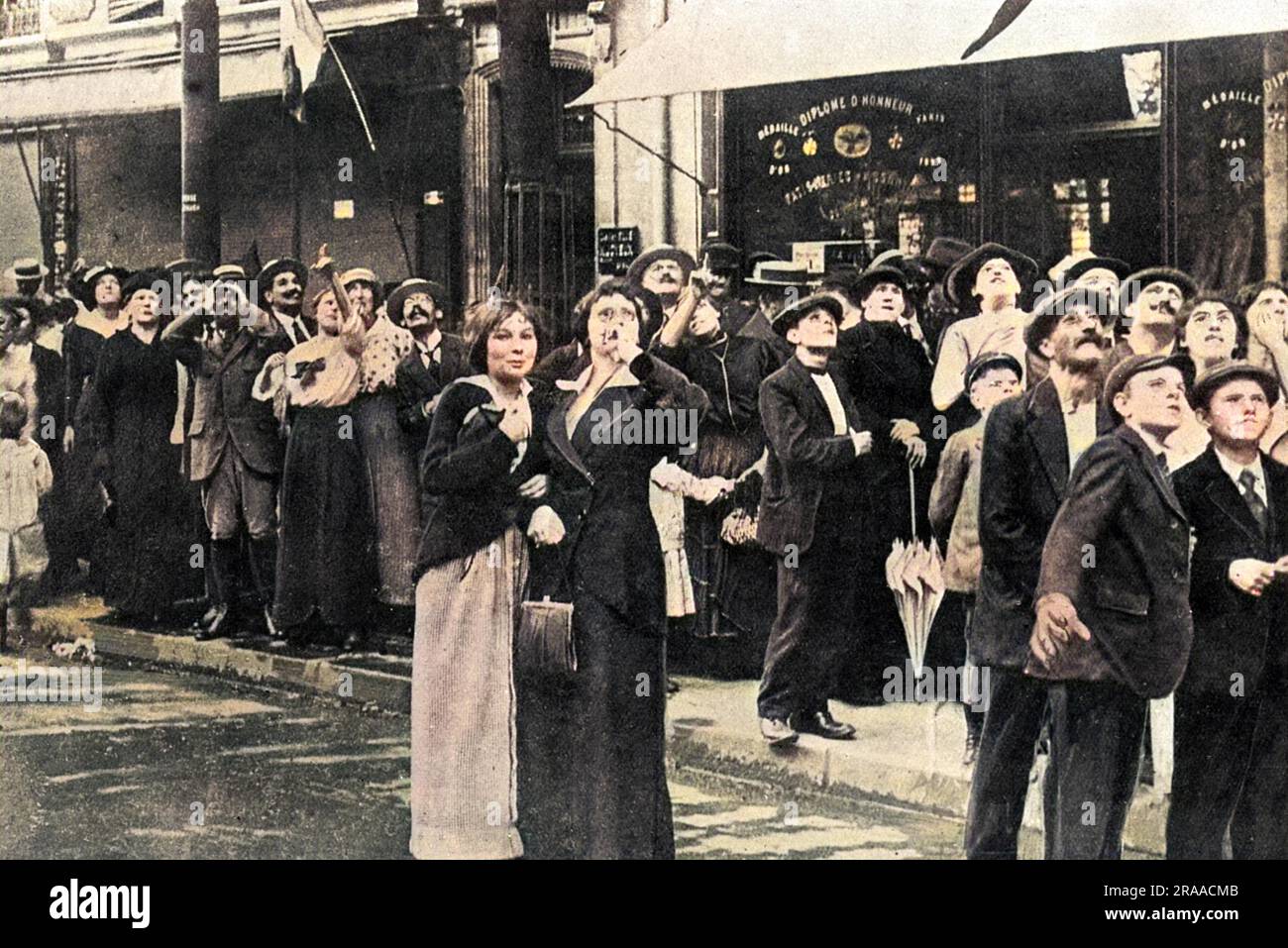 Les Parisiens photographiés dans l'un des boulevards de la ville, regardant des gratte-ciel, ont l'intention de faire des manœuvres d'un avion allemand Taube. Date: 1914 Banque D'Images