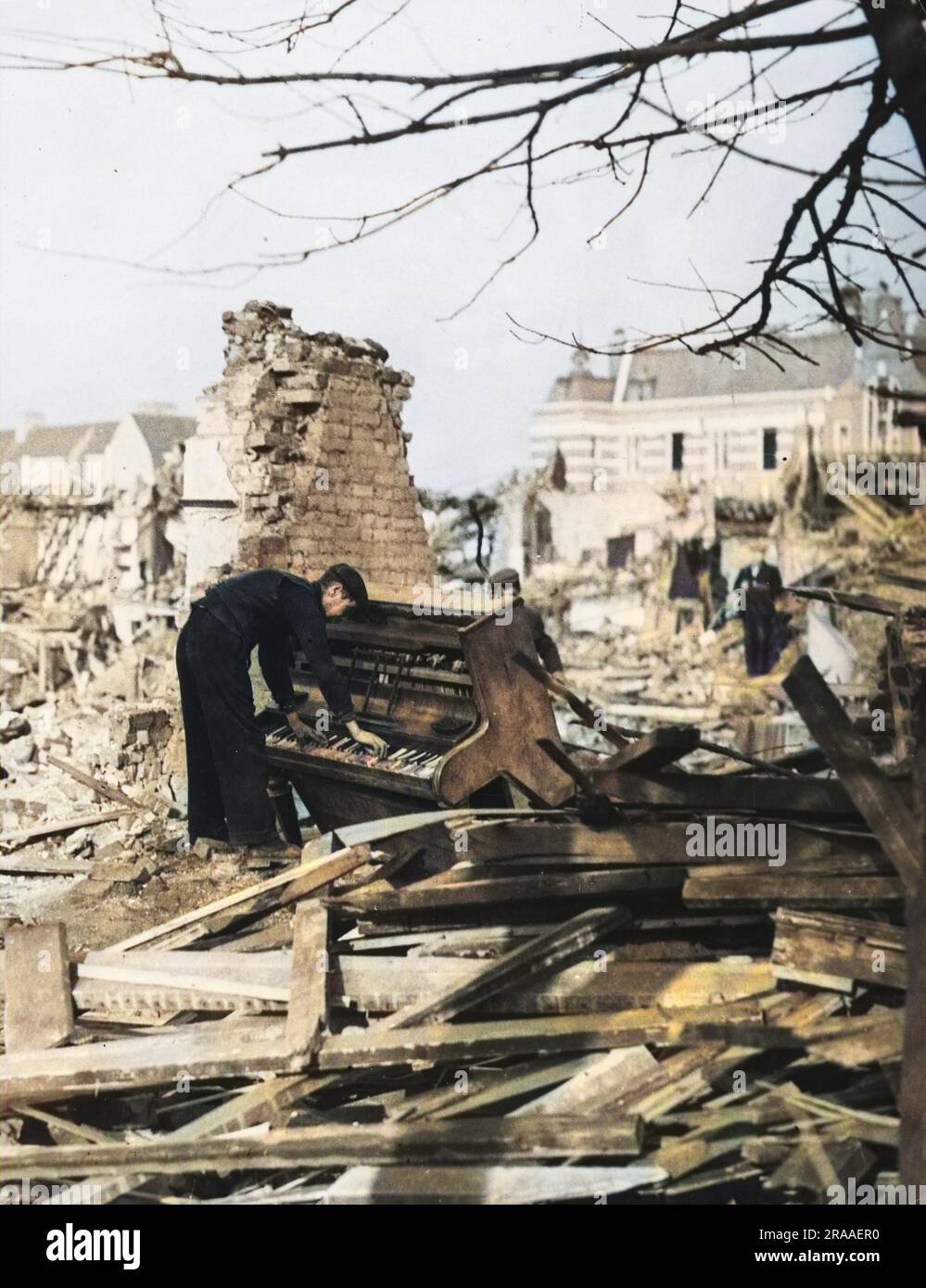 Un des hommes travaillant sur le décomiement des débris à Londres a réussi à se reposer une mélodie de ce piano battu û vers la fin de 1940. Date: Fin 1940 Banque D'Images
