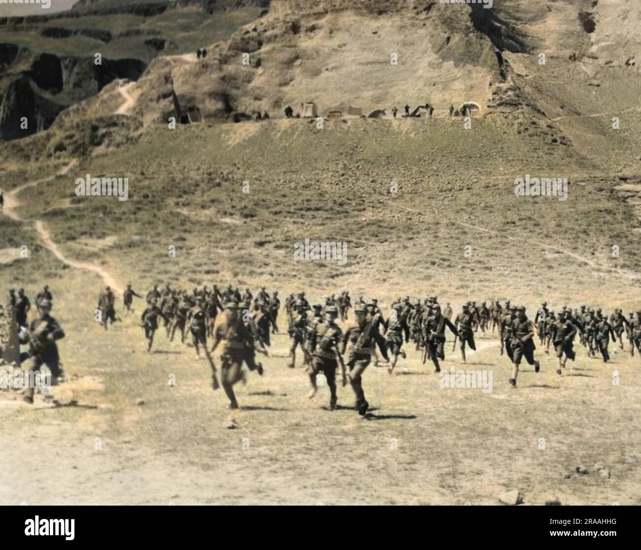 Les étudiants de l'Université politique et militaire anti-japonaise pratiquent l'une de leurs attaques surprise sur le terrain d'exercice. L'Université a été créée à Yenan, la capitale communiste chinoise en 1937. En arrière-plan sont les collines de Loess avec des grottes utilisées comme logements Date: 1937-1945 Banque D'Images