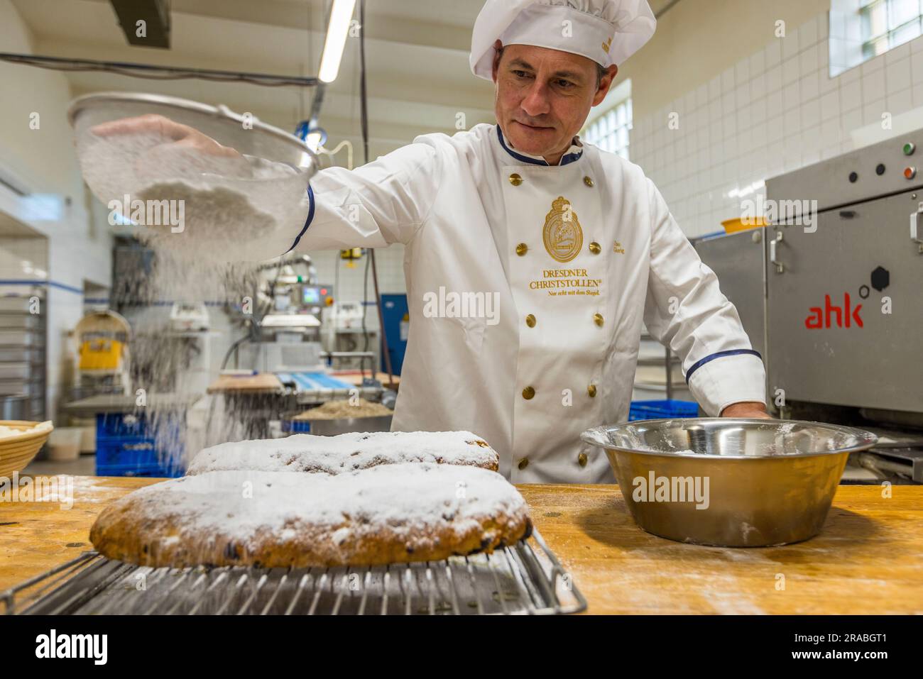Production d'un Christstollen Dresde original à Dresde, Allemagne. Le Stollen obtient son épaisse couche de sucre en poudre. Le sucre blanc en poudre est un symbole chrétien et est censé représenter le bébé Jésus enveloppé dans un tissu Banque D'Images