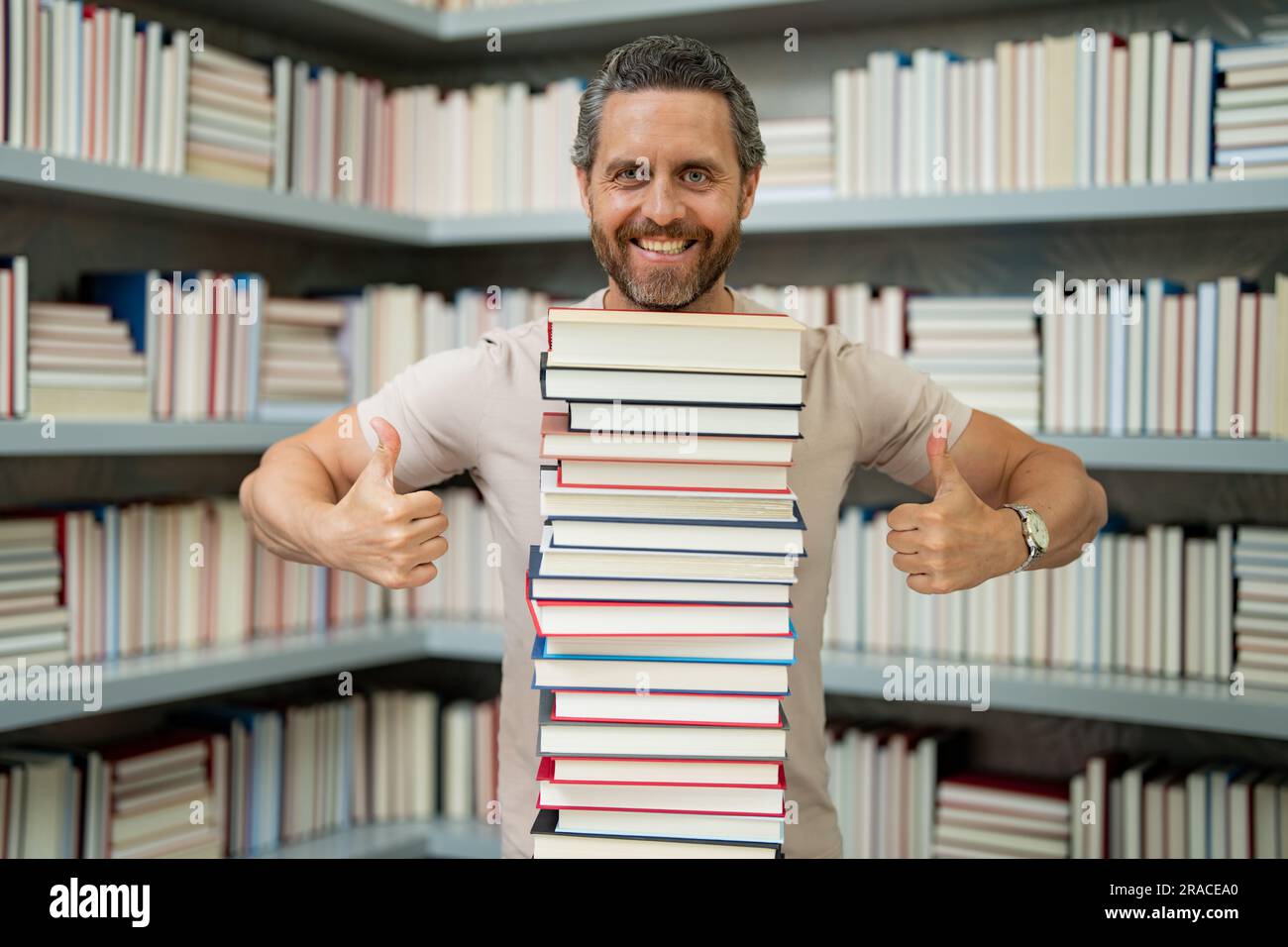 Portrait de l'enseignant dans la salle de classe de la bibliothèque. Enseignants de la bibliothèque universitaire. Journée des enseignants. Drôle d'enseignant de tenir beaucoup de livres. Professeur fou avec des livres Banque D'Images