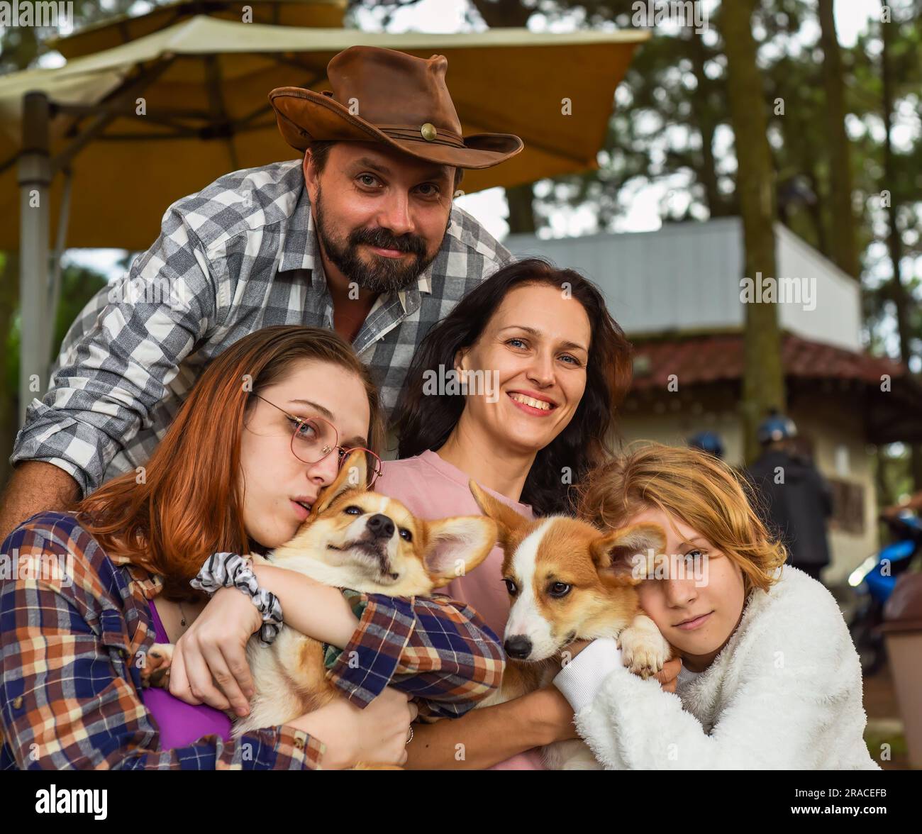 Membres de la famille père, mère et deux filles avec des chiens corgi dans la forêt Banque D'Images