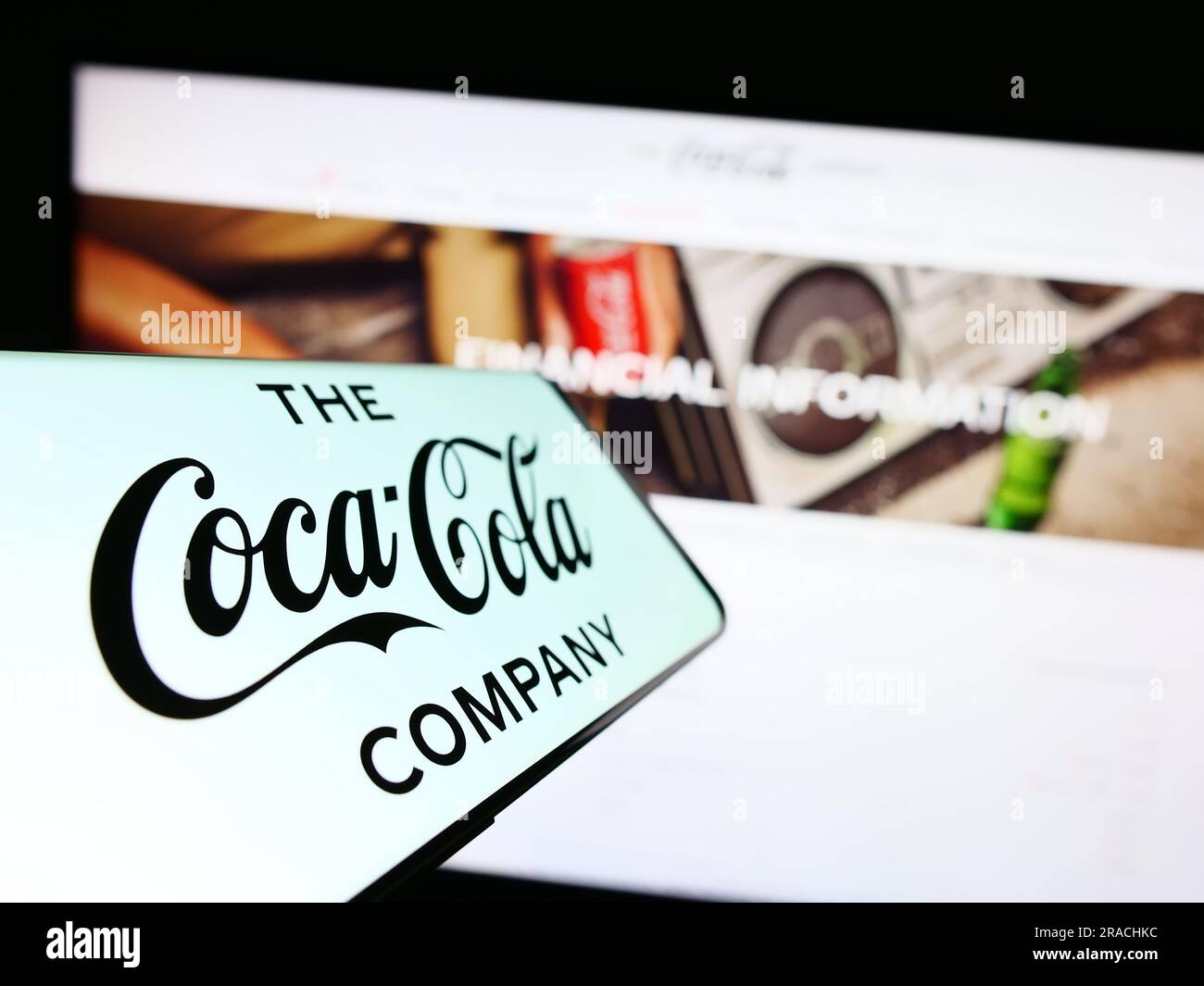 Téléphone portable avec logo de l'entreprise américaine de boissons The Coca-Cola Company sur l'écran en face du site Web. Concentrez-vous sur le centre gauche de l'écran du téléphone. Banque D'Images