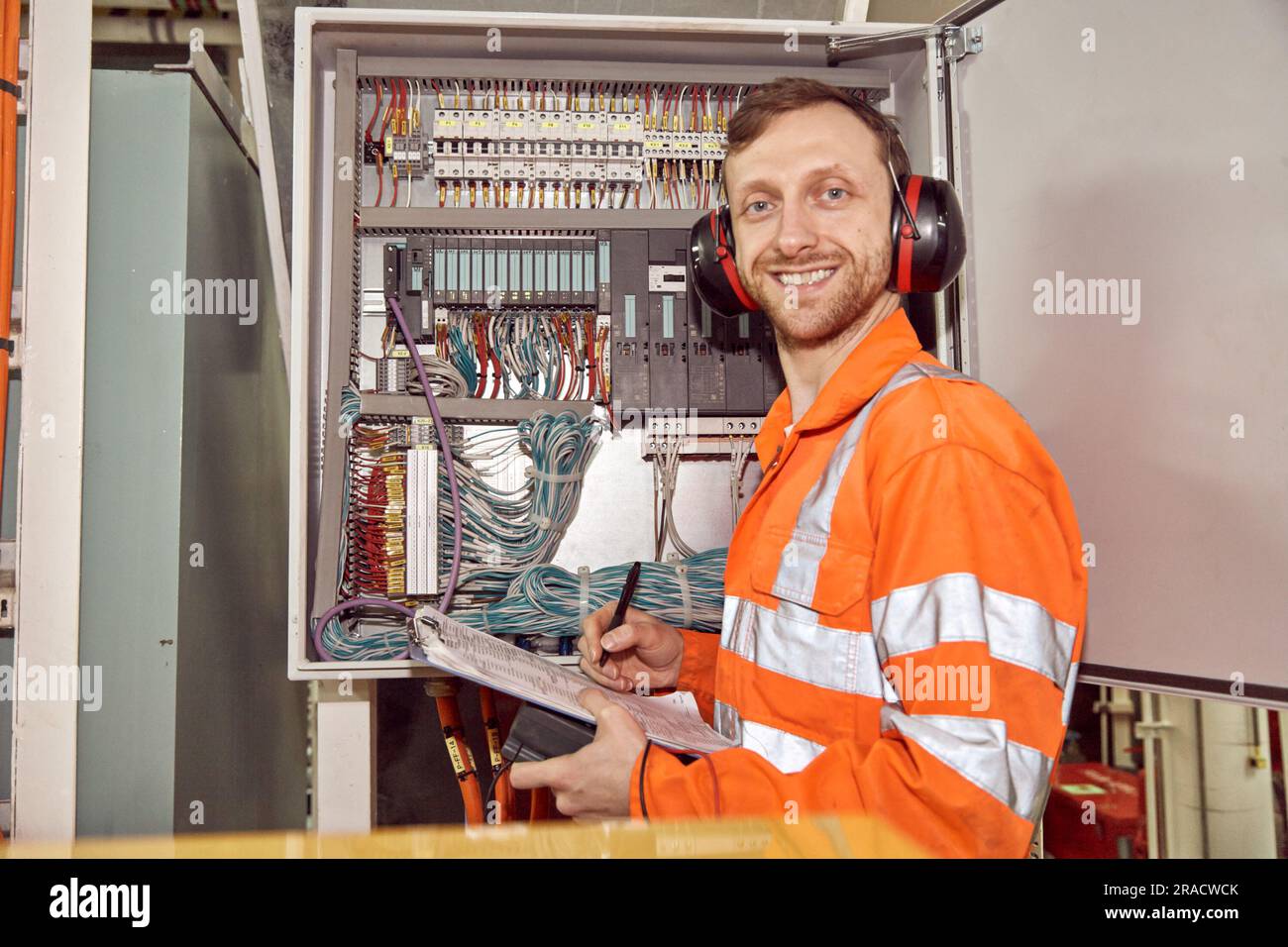 Ingénieur électricien offshore vérifiant l'équipement électrique. Jeune professionnel du pétrole et du gaz. Banque D'Images