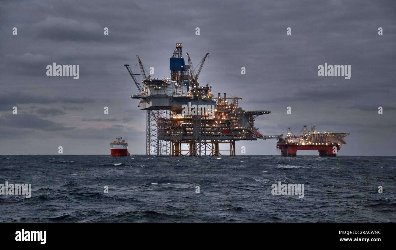 Production de pétrole et de gaz offshore dans la mer par temps orageux au crépuscule. Banque D'Images