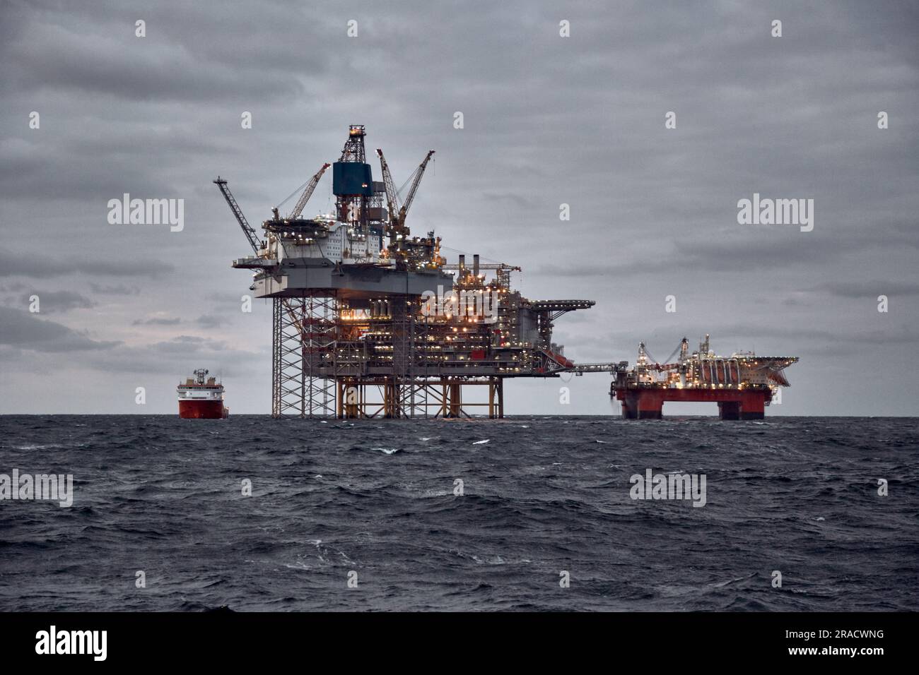 Image de la production de pétrole et de gaz offshore dans la mer par temps orageux au crépuscule. Jack up, semi submersible plates-formes de production de pétrole brut dans l'océan. Banque D'Images