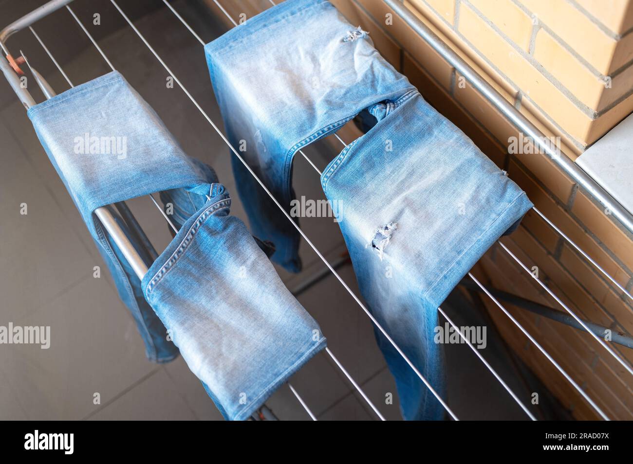 Séchage du Jean sur le sèche-linge. Jean bleu humide séchant dans  l'appartement sur le sèche-linge Photo Stock - Alamy