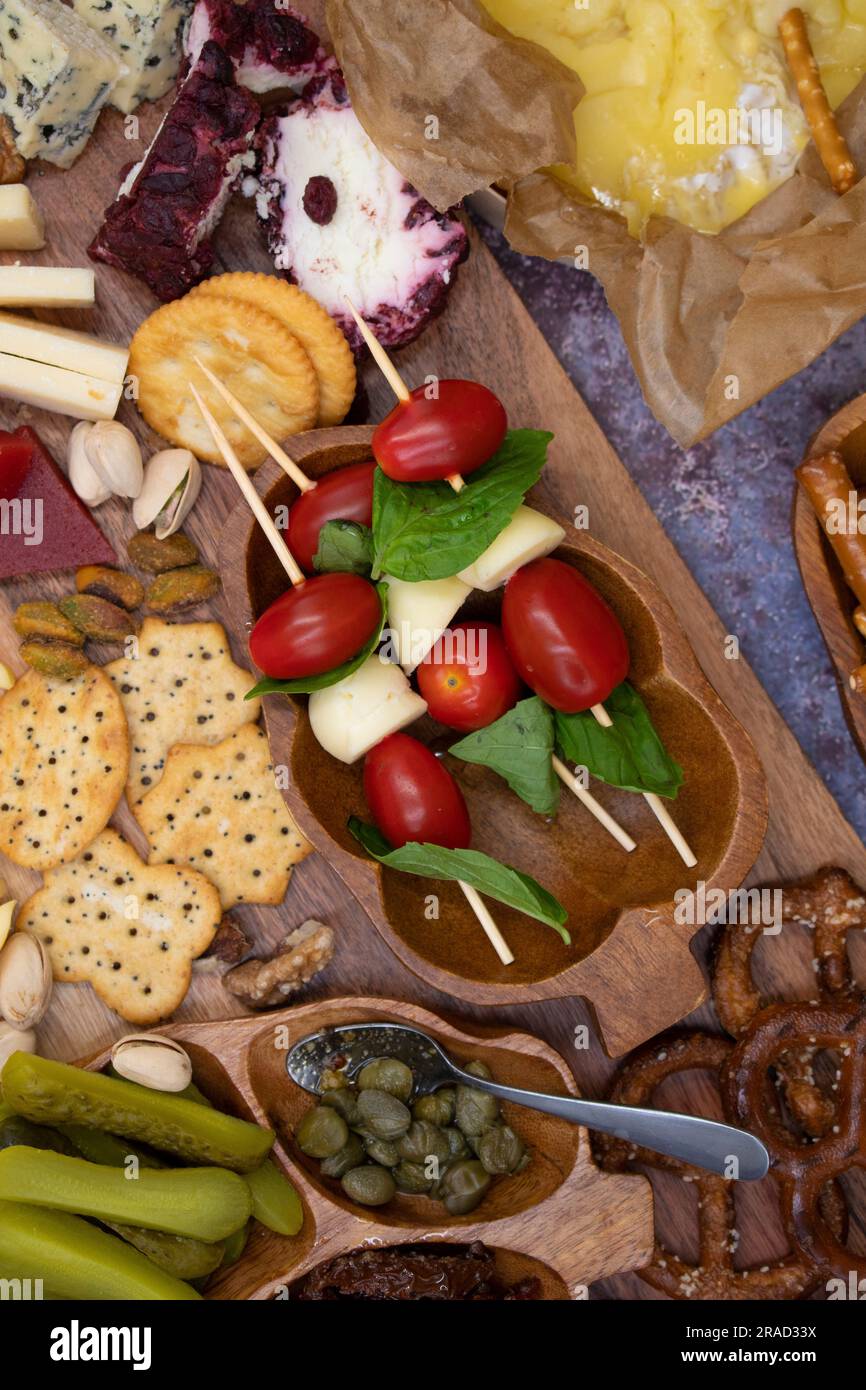 Tableau de hors-d'œuvre avec caprese, crackers, fromage, fruits et ...