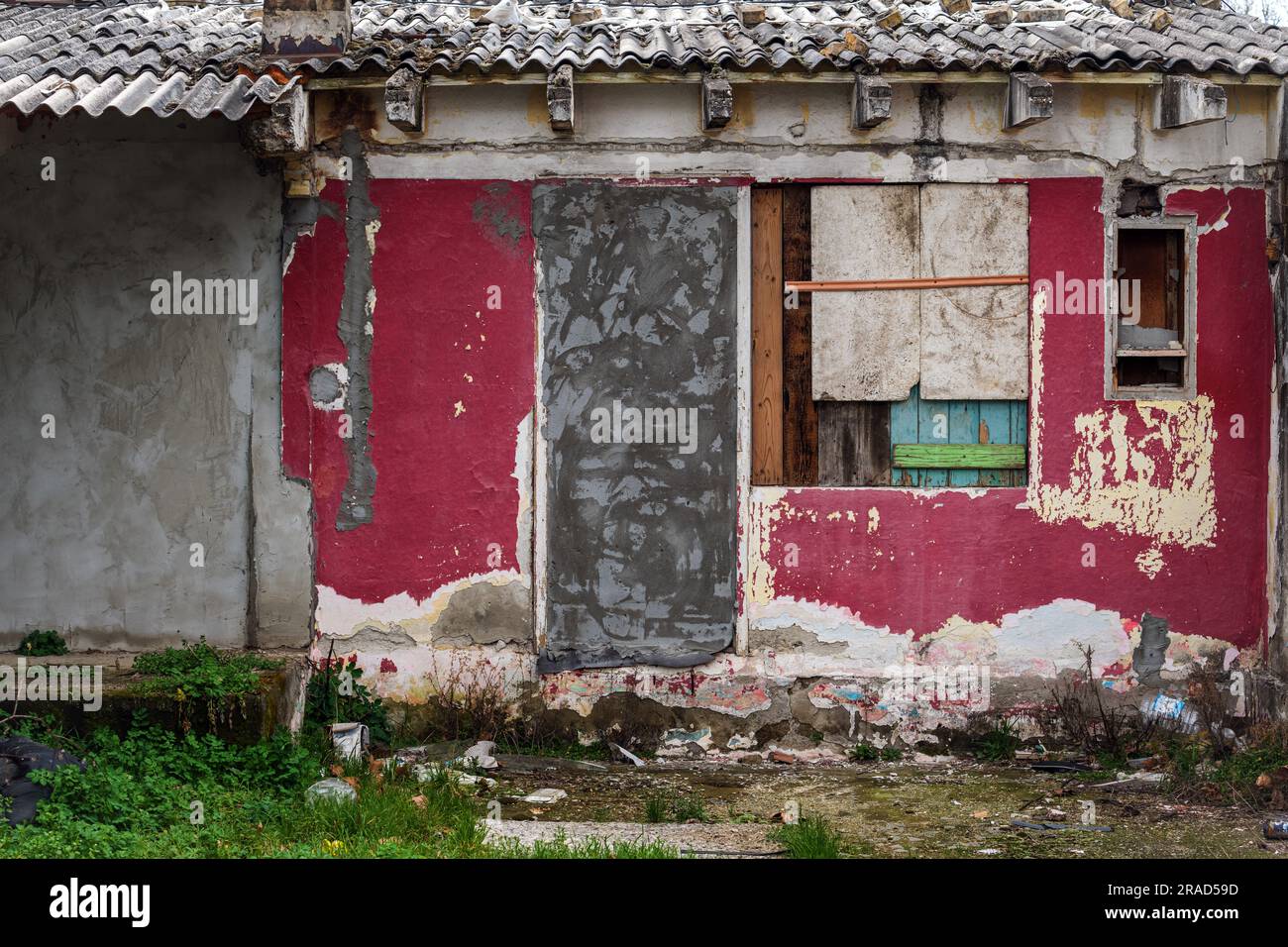 Ancienne maison ruinée dans le taudis avec façade détériorée avec des fenêtres fermées et des portes murées Banque D'Images