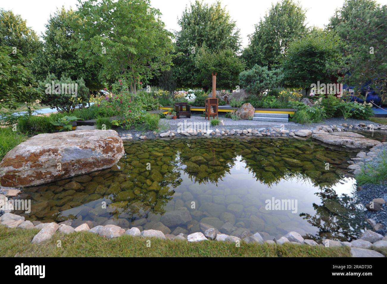 Journée d'ouverture à la Royal Horticultural Society 2023 Hampton court Palace Garden Festival - l'un des jardins de spectacle exposés: Hurtigruten: Le jardin relation-bateau le jardin met en évidence la relation entre Hurtigruten et ses agriculteurs côtiers norvégiens. L'espace se concentre spécifiquement sur un fruitier basé dans le sud-ouest de la Norvège qui a créé un jardin au bord du lac pour lui-même profiter après des années de travail dur sur sa ferme familiale. Le Hampton court Palace Garden Festival, qui a lieu depuis 1993, est le plus prestigieux événement de fleurs et de jardins au Royaume-Uni et la plus grande ann au monde Banque D'Images