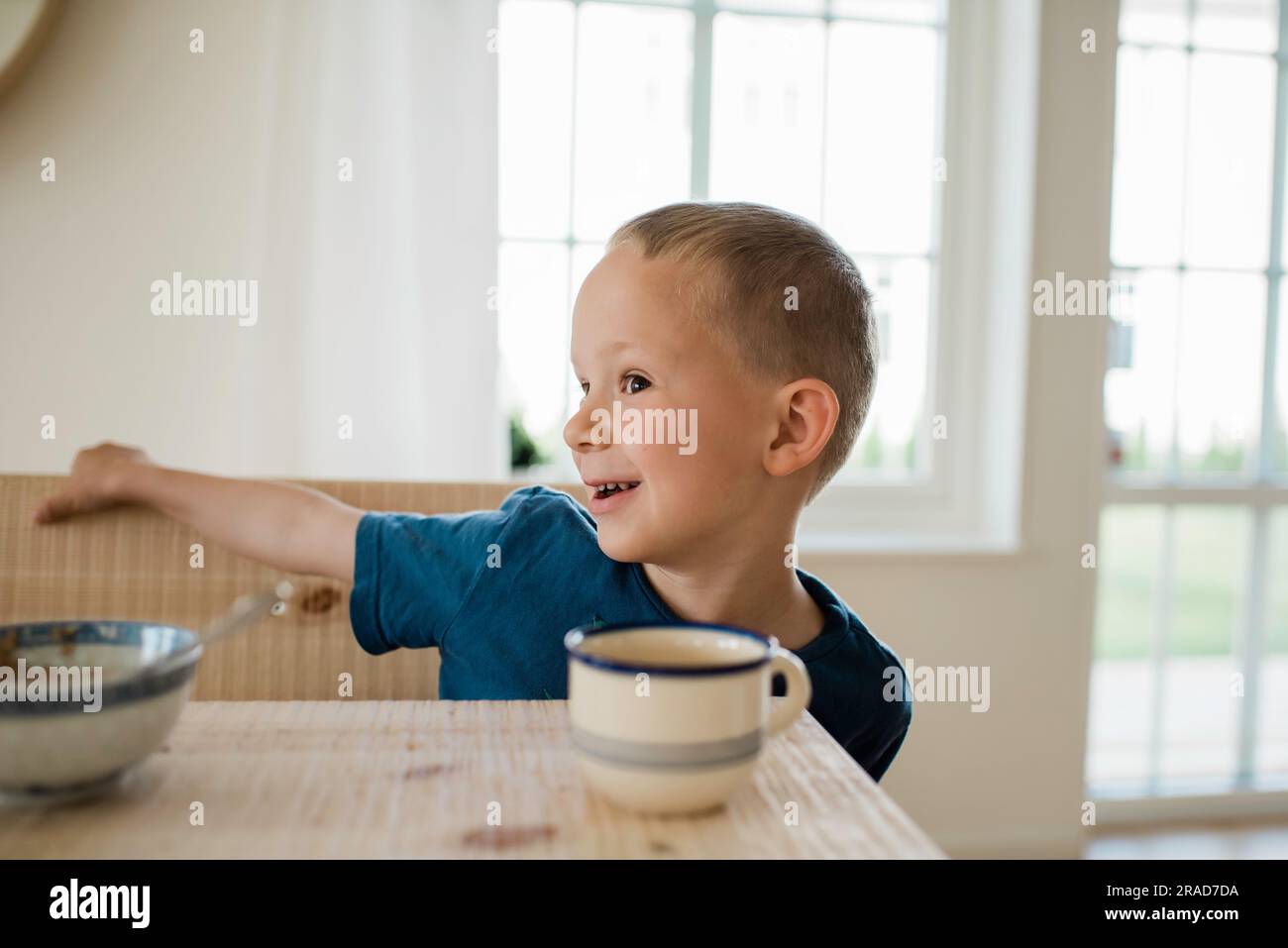 portrait d'un jeune garçon jouant à la table du petit déjeuner Banque D'Images