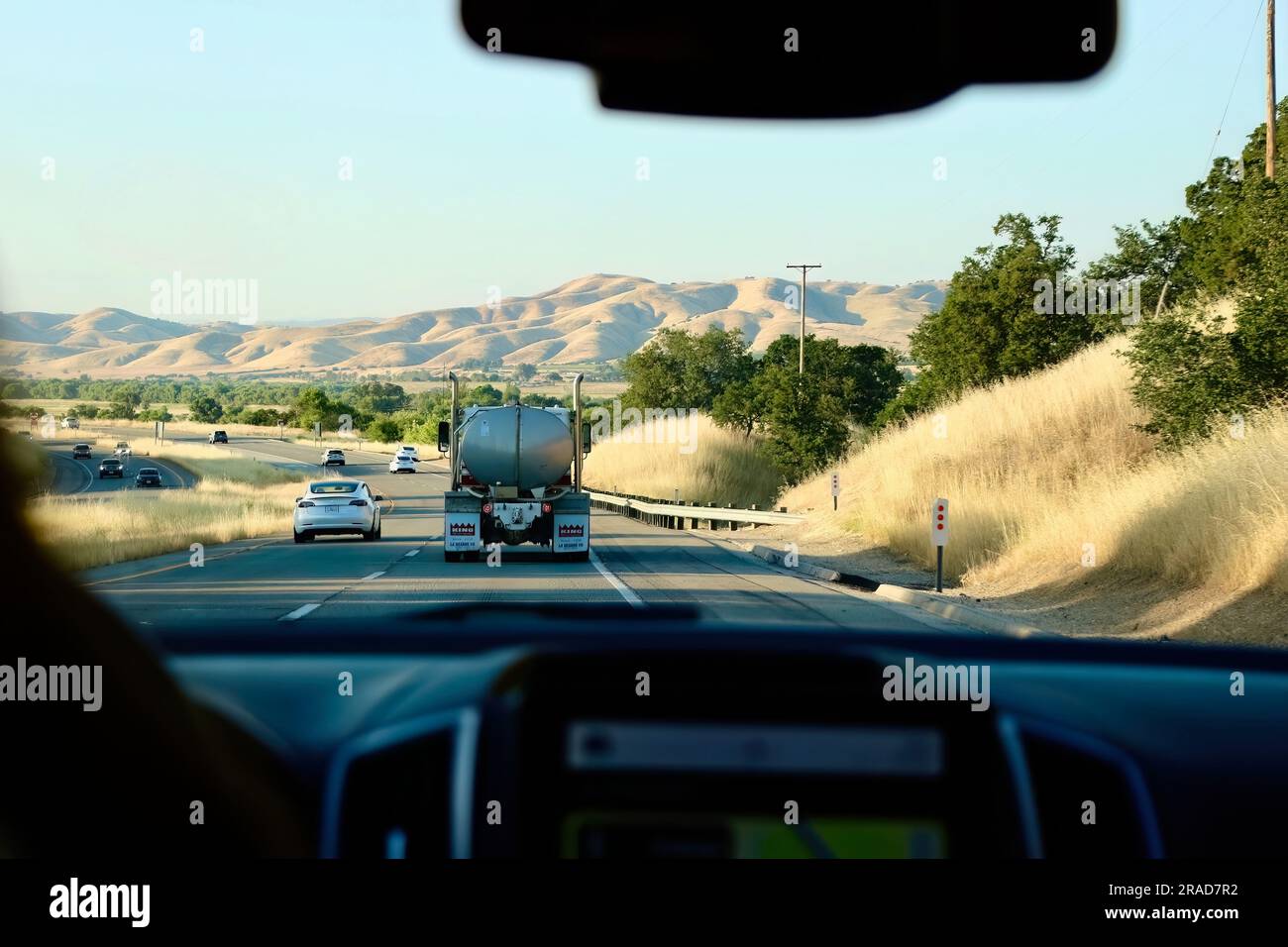 Une voiture électrique Tesla passant devant un camion-citerne sur l'US Highway 101 Old versus New depuis l'intérieur d'une voiture voyageant au nord de la Californie USA Banque D'Images