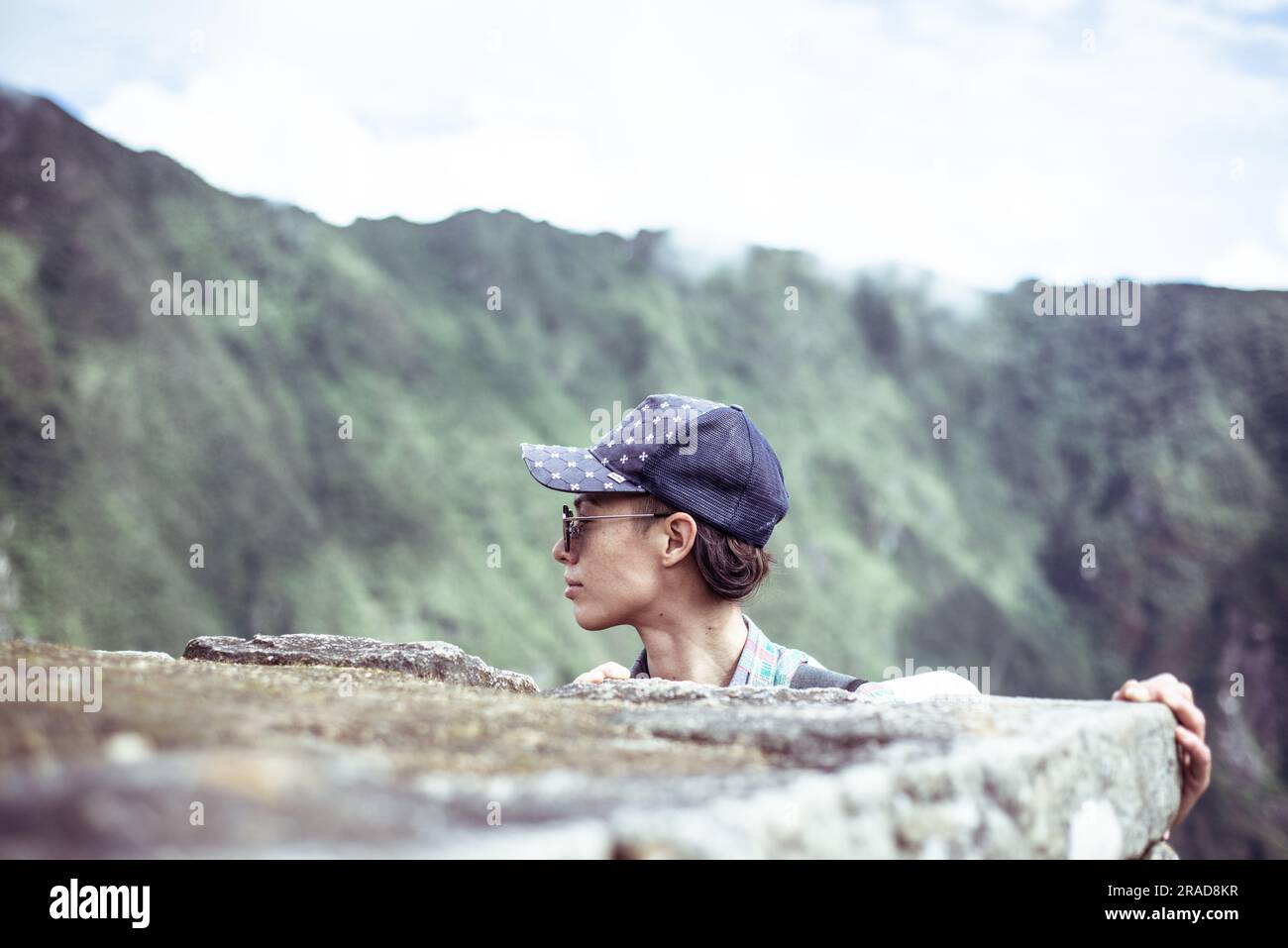 une femme androgyne regarde les montagnes dans les ruines de la ville de machu picchu Banque D'Images