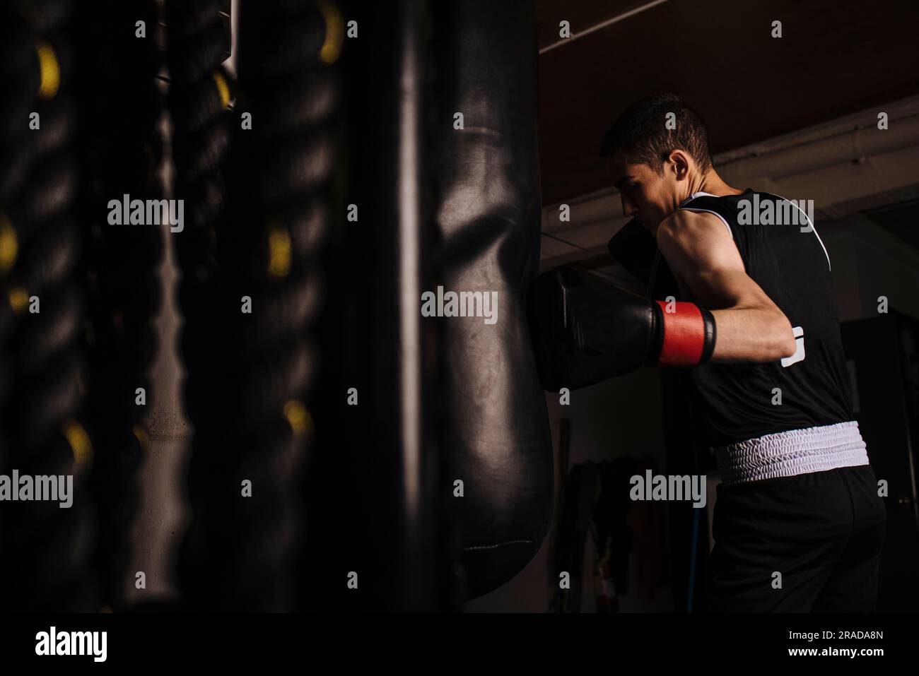 Boxeur jeune homme pratiquant une boxe à gauche pendant l'entraînement. Banque D'Images