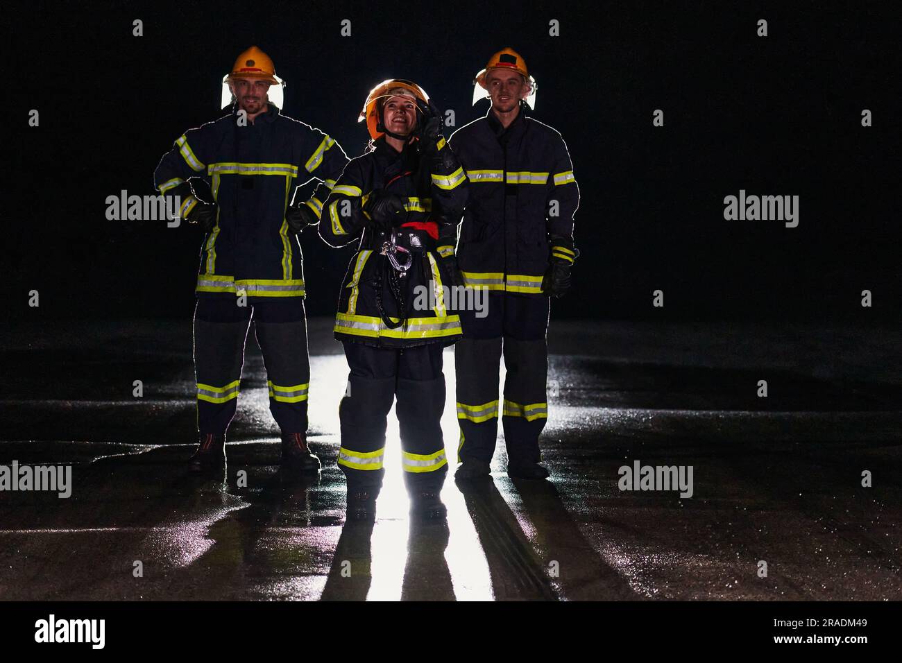 Un groupe de pompiers professionnels marchant la nuit dans une mission de sauvetage, leurs progrès déterminés et les expressions effrayantes reflétant leur Banque D'Images