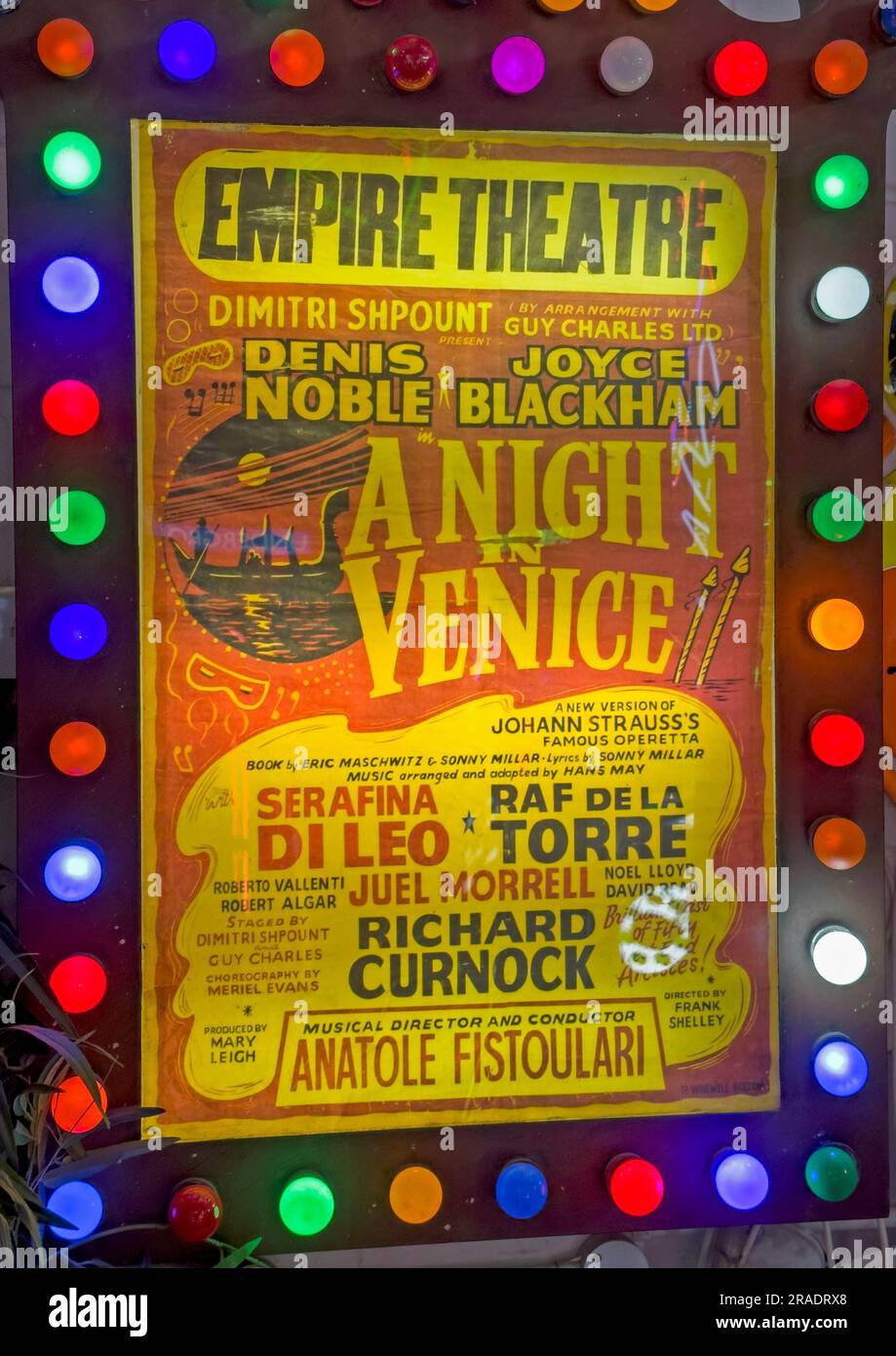 Affiche de l'Empire Theatre annonçant une production scénique, affichée dans un cadre éclairé entouré de lumières colorées Banque D'Images