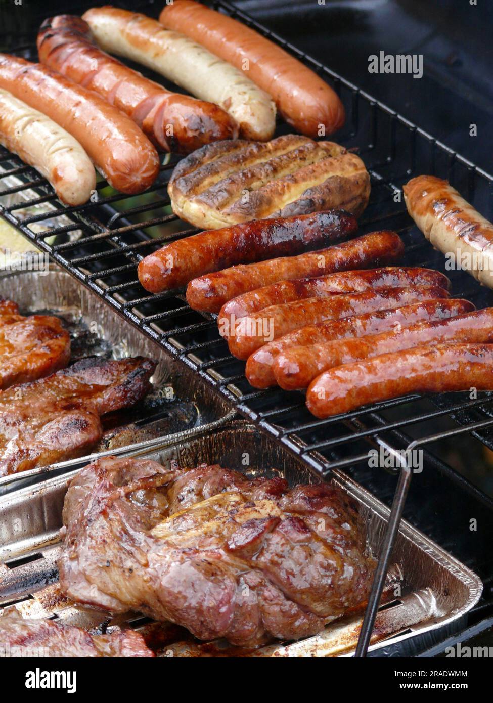 Barbecue à gaz avec divers aliments grillés, saucisses avec viande sur le  barbecue, barbecue Photo Stock - Alamy