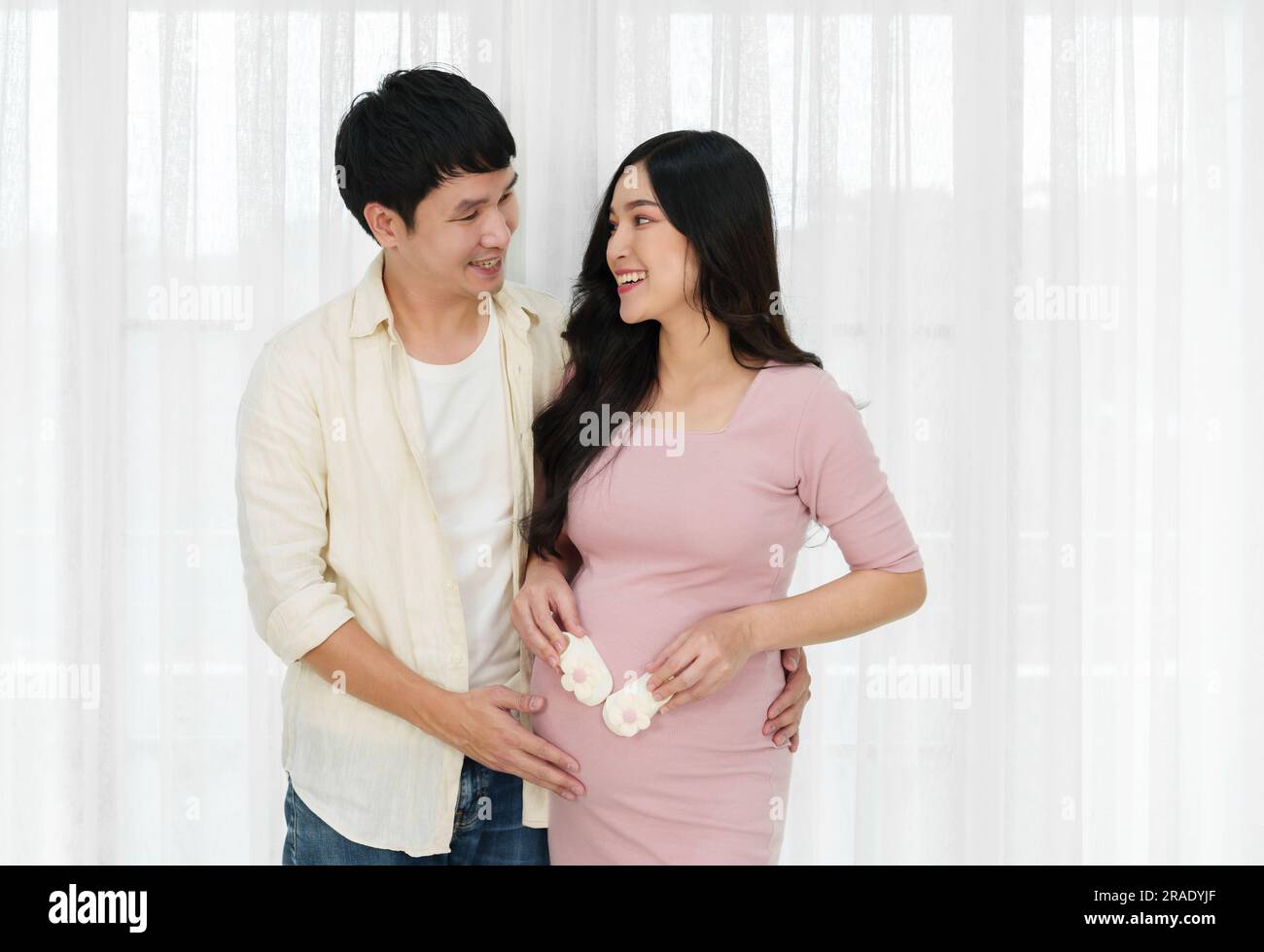 mari et sa femme enceinte avec une chaussette ou une chaussure pour bébé sur le ventre Banque D'Images
