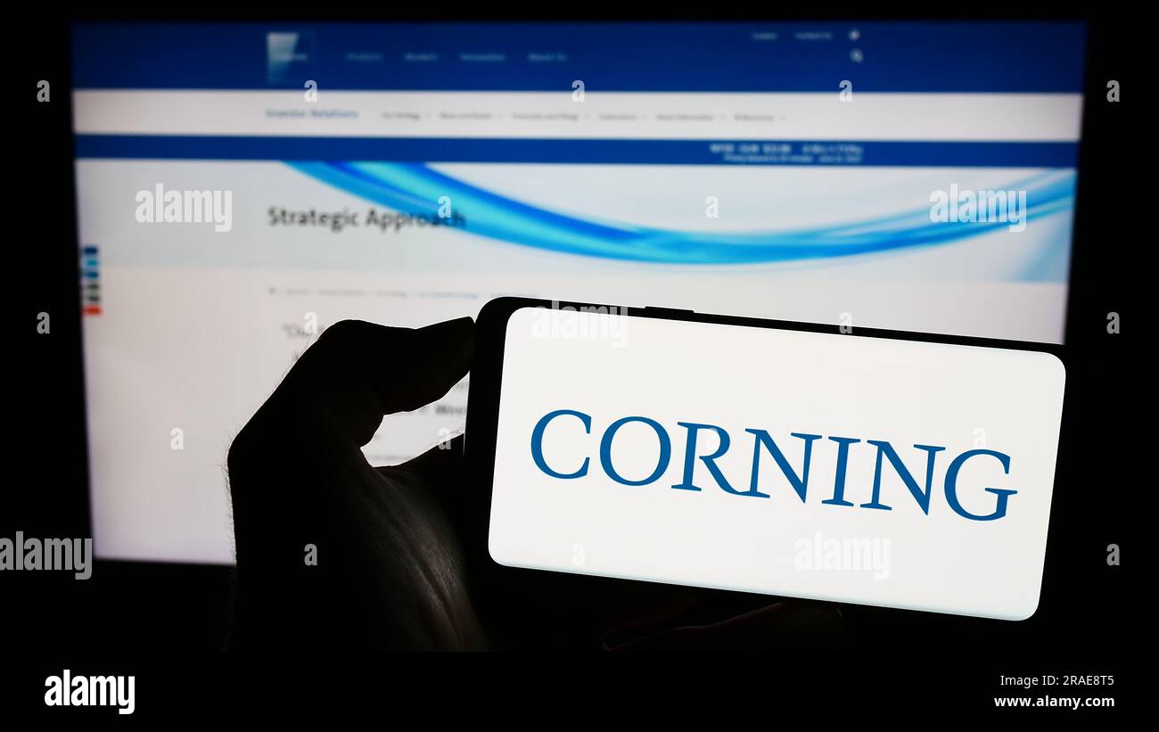 Personne détenant un smartphone avec le logo de la société technologique américaine Corning Incorporated sur l'écran devant le site Web. Concentrez-vous sur l'affichage du téléphone. Banque D'Images