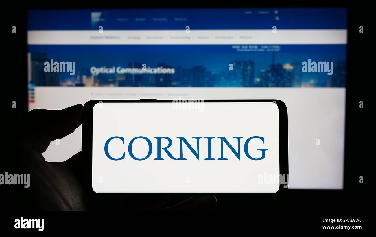 Personne tenant un téléphone portable avec le logo de la société de technologie américaine Corning Incorporated sur l'écran devant la page Web de l'entreprise. Concentrez-vous sur l'affichage du téléphone. Banque D'Images