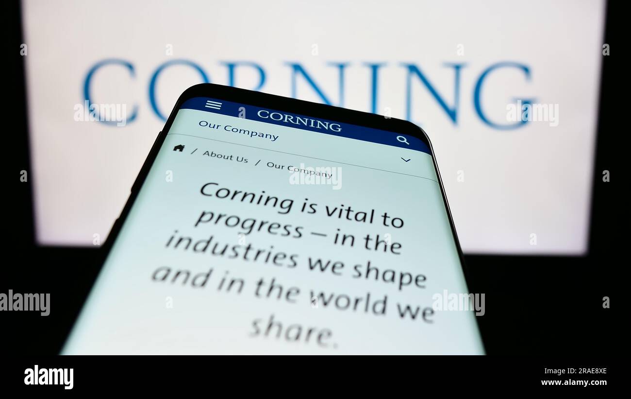 Téléphone mobile avec page Web de la société technologique américaine Corning Incorporated à l'écran devant le logo de l'entreprise. Effectuez le focus sur le coin supérieur gauche de l'écran du téléphone. Banque D'Images