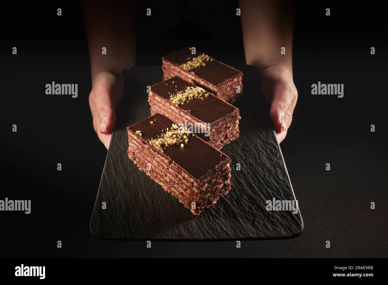 Gâteau au chocolat avec noix et pistache isolés sur fond noir. Pâtisserie de la boulangerie maison Banque D'Images