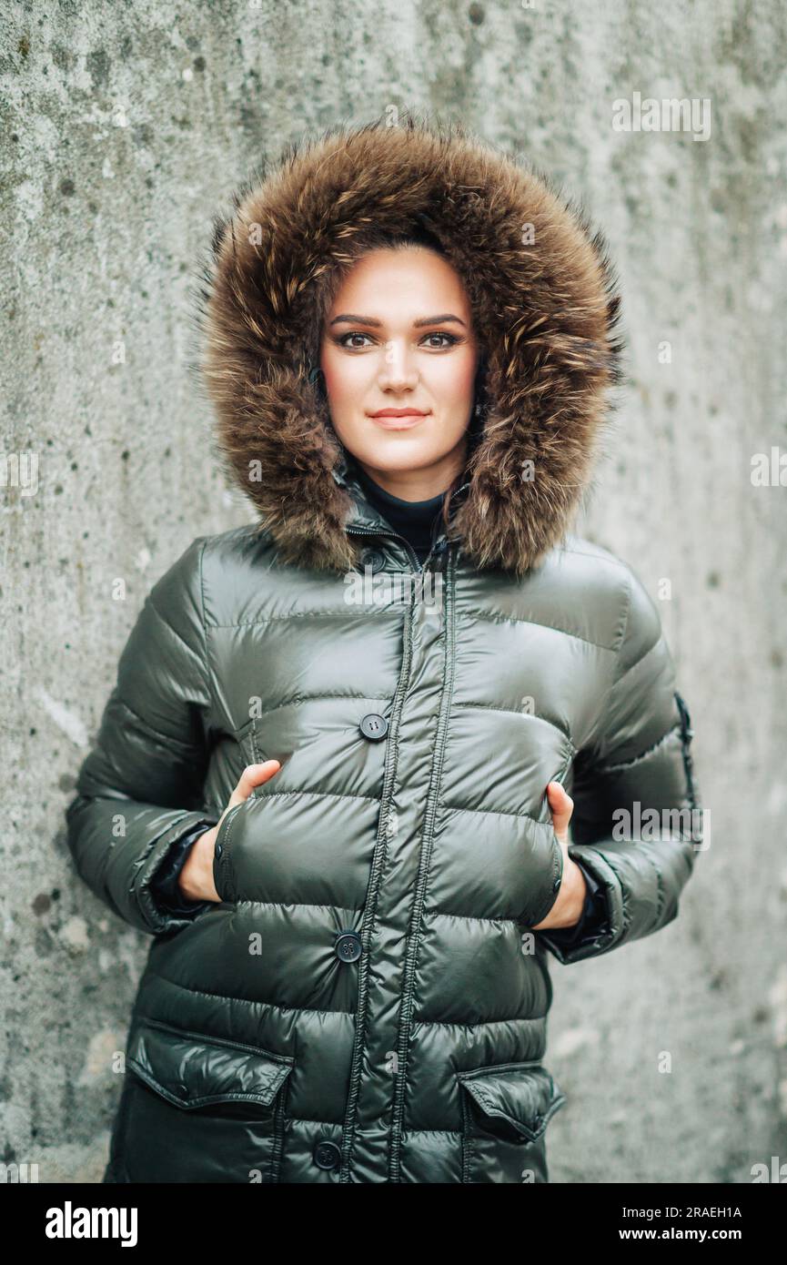 Portrait d'hiver d'une belle femme au maquillage sombre, portant une veste chaude avec capuche en fourrure Banque D'Images