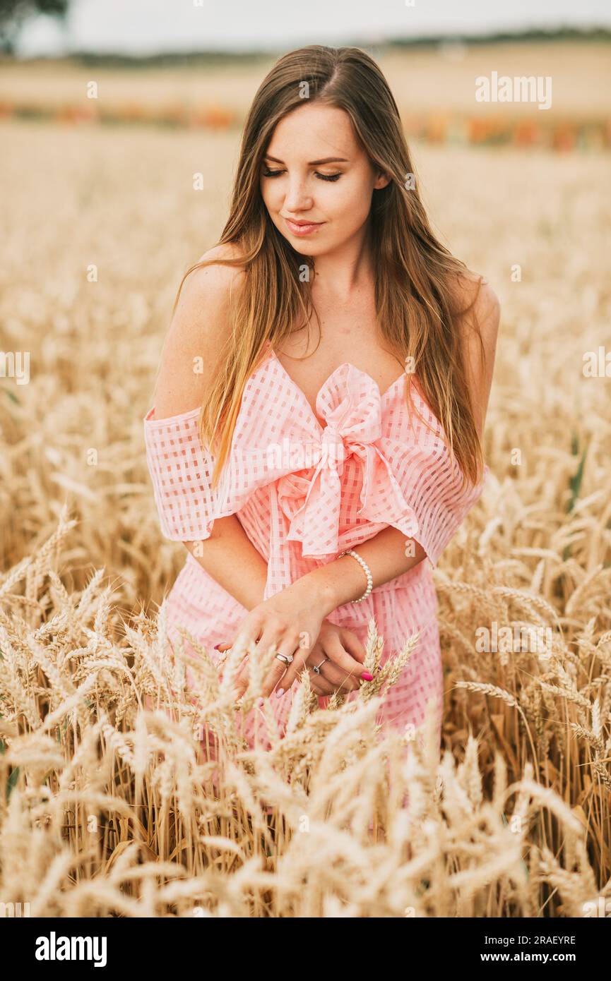 Portrait d'été de la jeune femme heureuse posant dans le champ de blé Banque D'Images