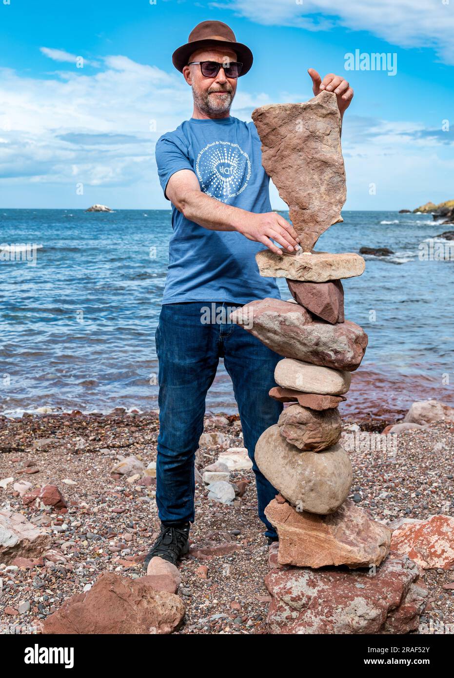 Dunbar, East Lothian, Écosse, Royaume-Uni, 3 juillet 2023. European Land Art Festival (ELAF) : l'événement annuel avec des événements sur la plage avec des ateliers donnés par des artistes professionnels du Land ainsi que des concours pour gerbeurs de pierre amateurs. Photo : l'organisateur de l'événement James Craig page met en pratique la création d'une pile de sculptures en pierre à Bayswell Beach. Crédit : Sally Anderson/Alamy Live News Banque D'Images