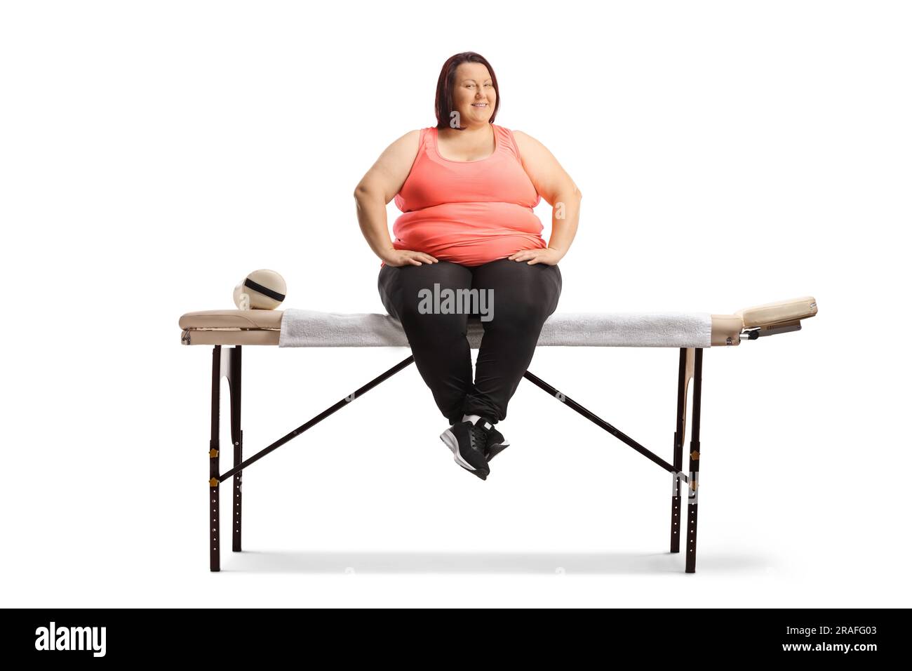 Femme en surpoids assise sur une table de massage isolée sur fond blanc Banque D'Images