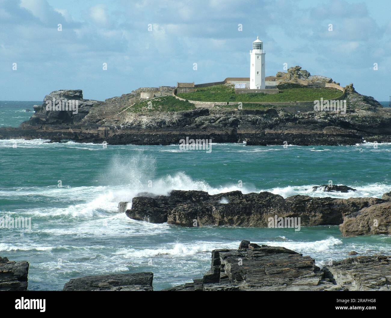 La lumière du soleil d'automne illumine la tour octogonale blanche de 26 mètres du phare de Godrevy. Construit à la fin des années 1850 et habité par trois gardiens de phare, Banque D'Images