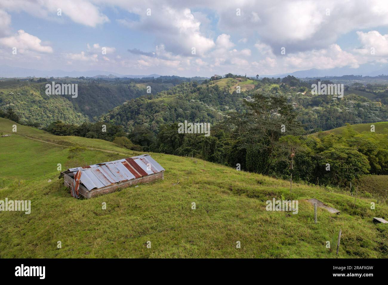 Vue aérienne d'une ancienne Grange avec toit en tôle Rusty près de Filandia, Quindio, Colombie, entouré de terres agricoles et de forêts Banque D'Images