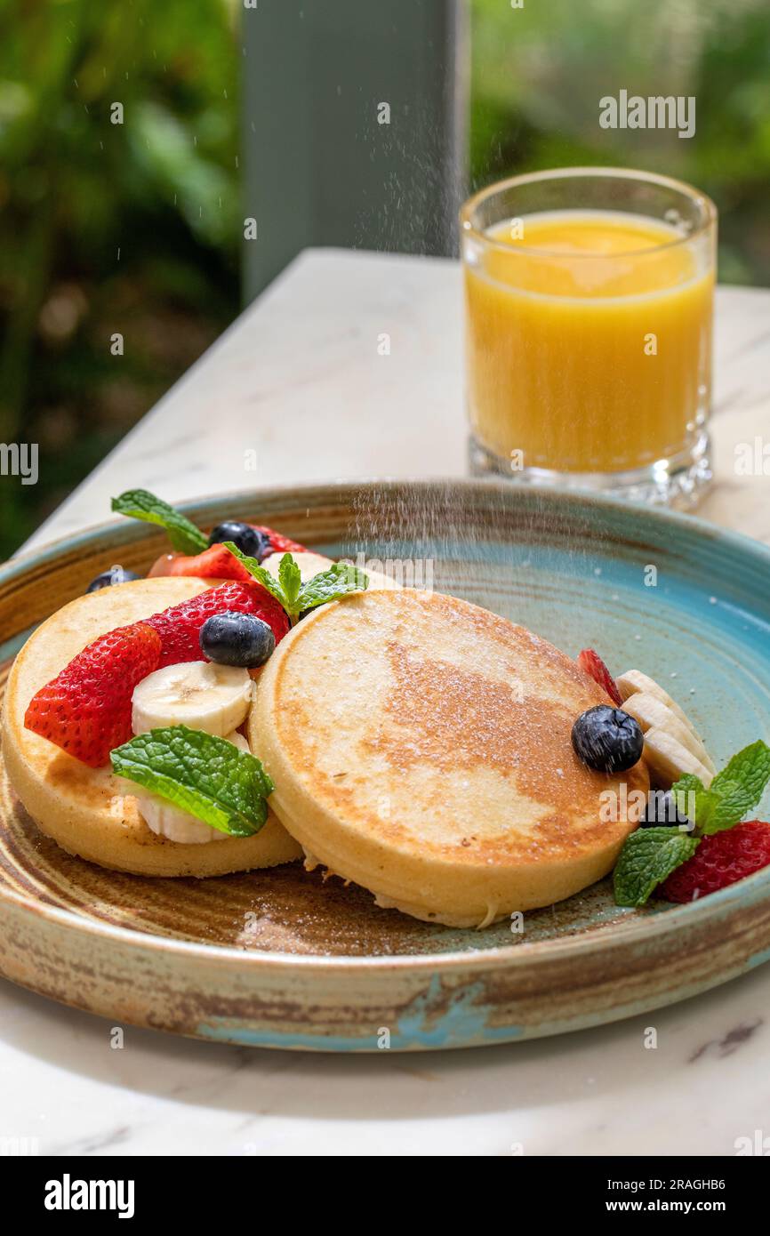 crêpes moelleuses avec des fruits sur un matin ensoleillé Banque D'Images