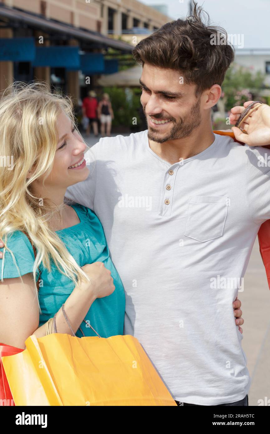 un jeune couple heureux qui marche en ville après avoir fait du shopping Banque D'Images