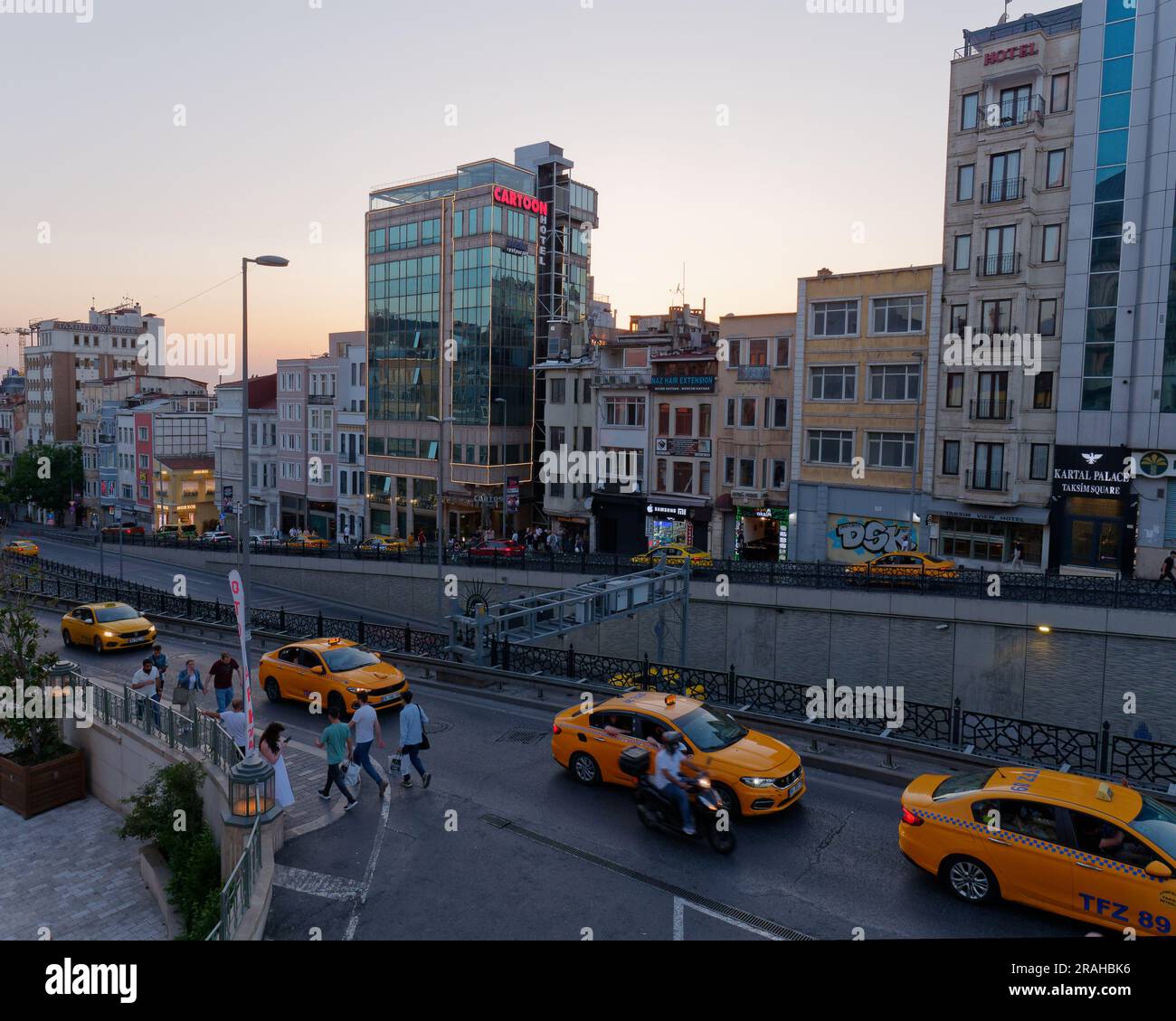 Taxis jaunes sur une rue animée surélevée près de la place Taksim sur un soir d'été Banque D'Images