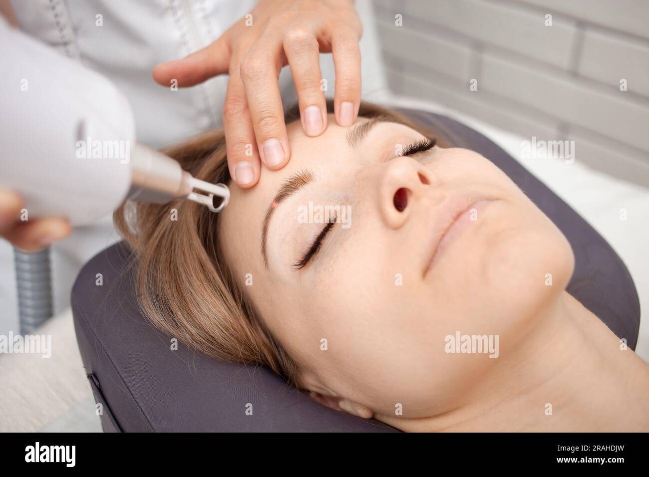 cosmétologue enlève le maquillage permanent, tatouage des sourcils avec laser Banque D'Images