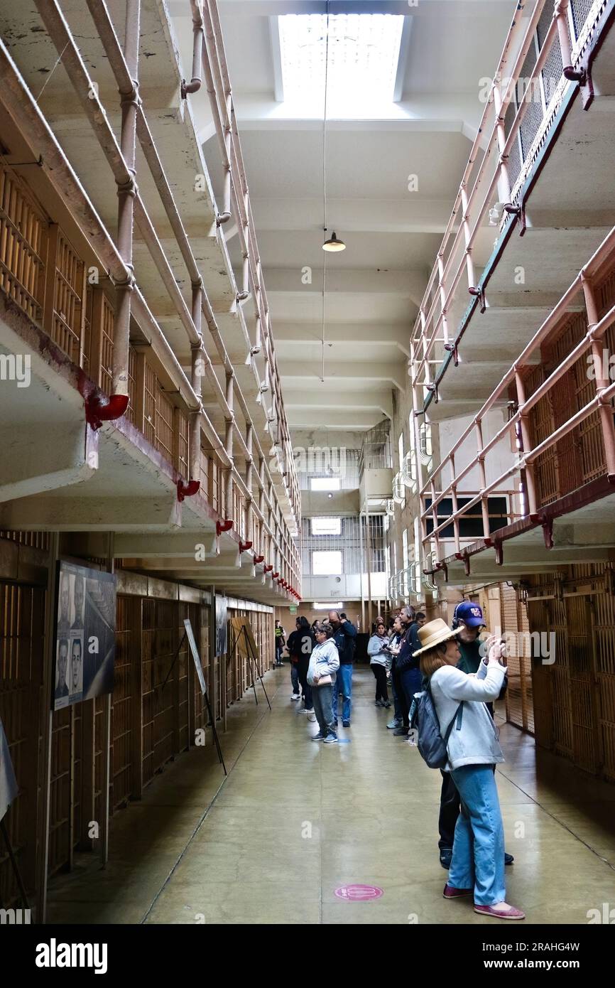 Touristes à l'intérieur du pénitencier fédéral d'Alcatraz regardant les couloirs avec des cellules de prison Alcatraz Island San Francisco Californie USA Banque D'Images