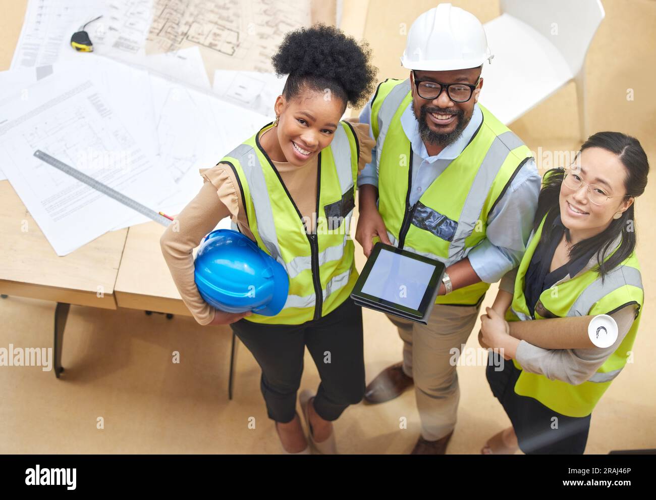 Tablette, travail d'équipe ou portrait d'ingénieurs avec un concepteur planifiant une construction pour l'architecture. Vue de dessus, plan ou heureux Noirs avec asiatique Banque D'Images