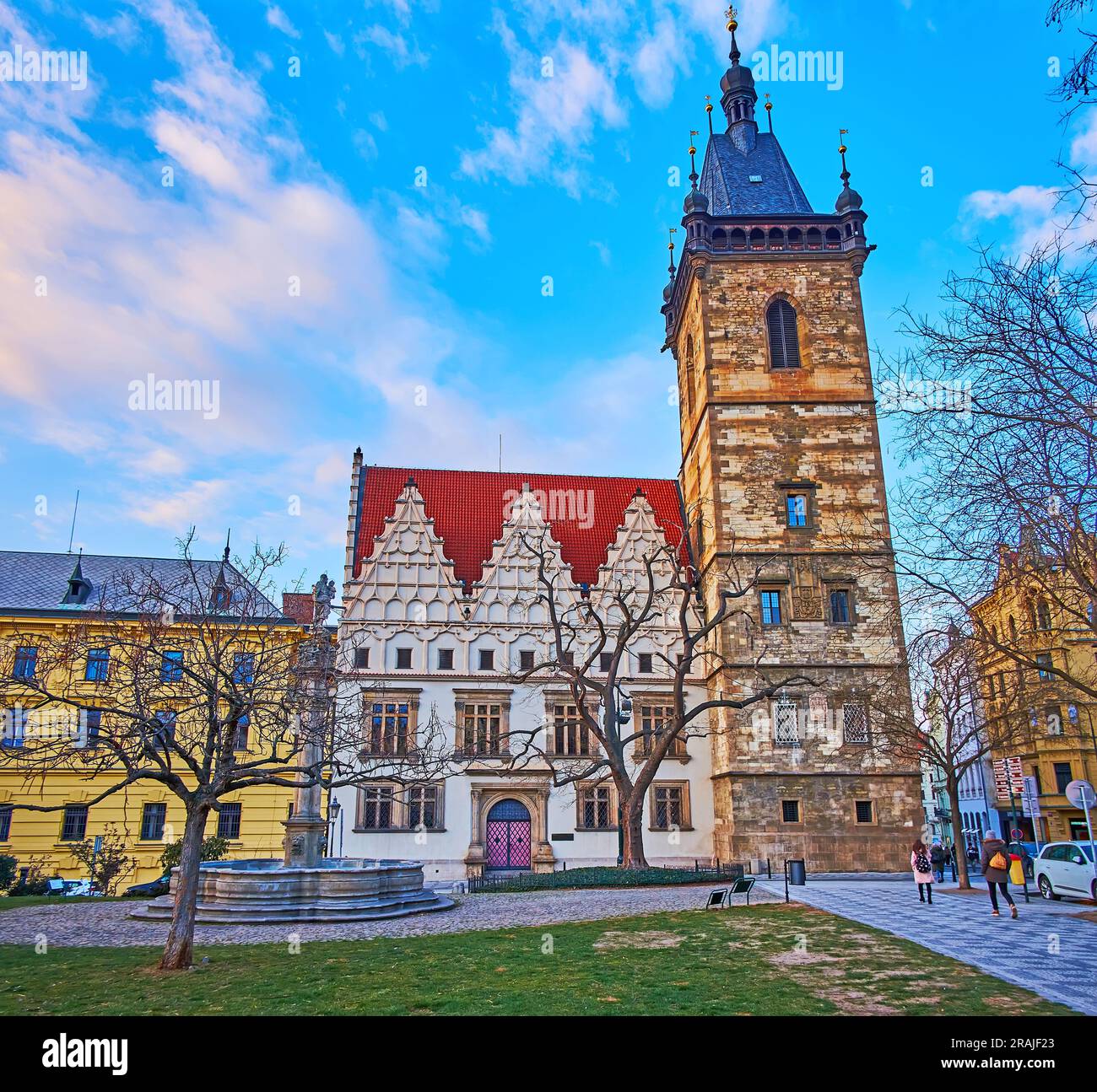 Fontaine avec colonne de peste sur la place Charles et le bâtiment médiéval de l'Hôtel de ville Nove Mesto contre le ciel bleu du soir, Prague, Tchéquie Banque D'Images
