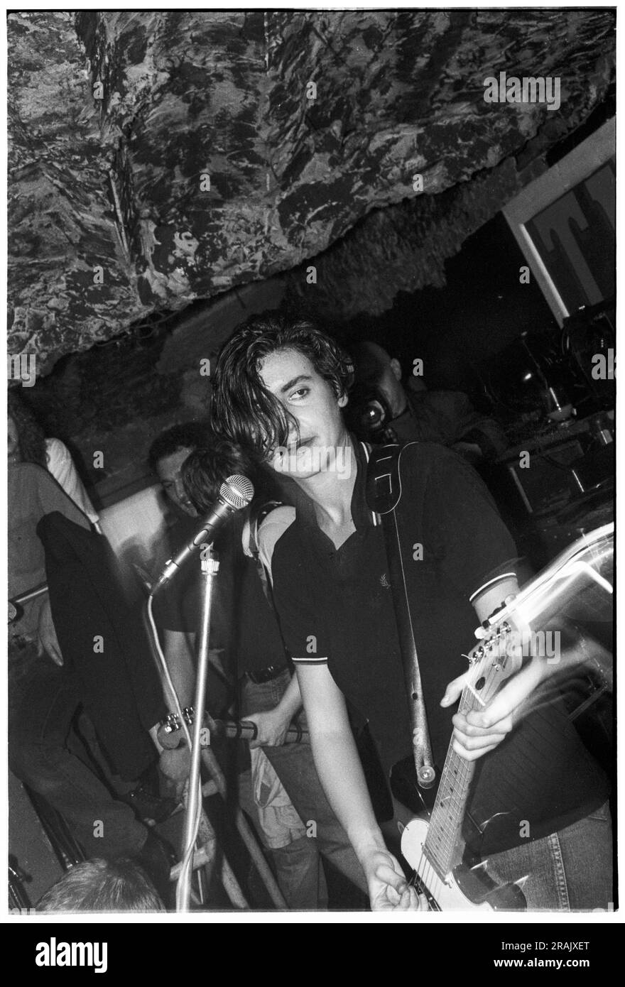 ELASTICA, YOUNG, EARLY GIG, 1994 : Justine Frischmann d'Elastica jouant un concert chaotique très tôt au légendaire TJS à Newport, pays de Galles, Royaume-Uni le 23 février 1994. Photo : Rob Watkins. INFO : Elastica, un groupe de rock alternatif britannique formé en 1992, est acclamé avec leur premier album éponyme. Des hits comme 'Connection' ont présenté leurs influences post-punk et New wave. Dirigée par Justine Frischmann, la contribution d'Elastica à l'ère Britpop est significative. Banque D'Images