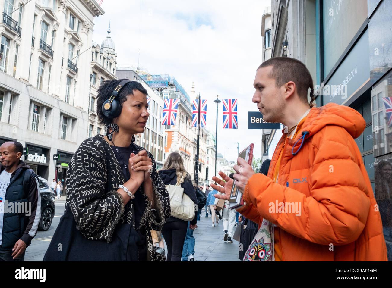 Londres - 2023 juin : un adepte de Hare Krishna parle à un acheteur sur Oxford Street Banque D'Images