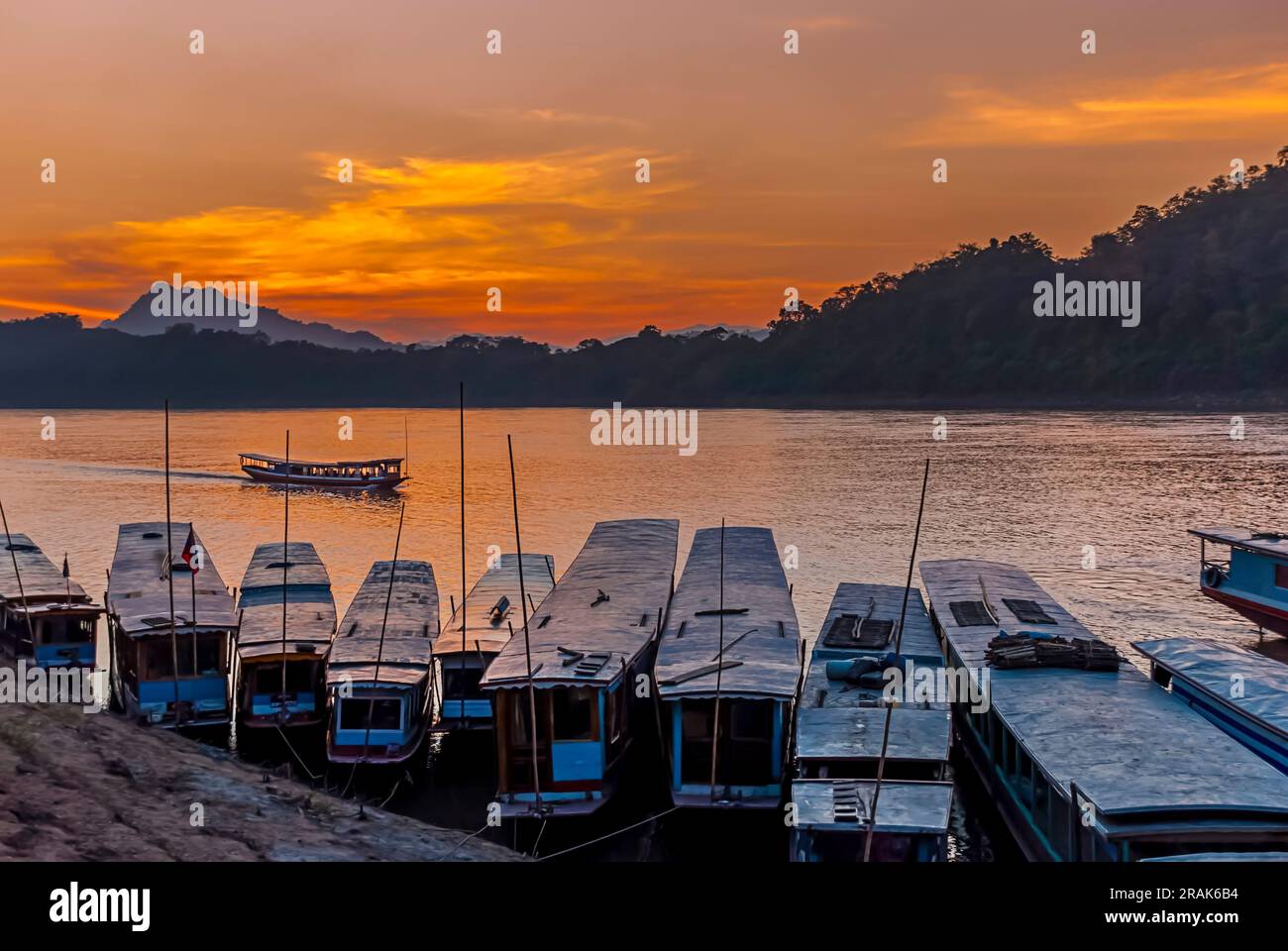Bateaux lents traditionnels au coucher du soleil à Luang Prabang, Laos Banque D'Images