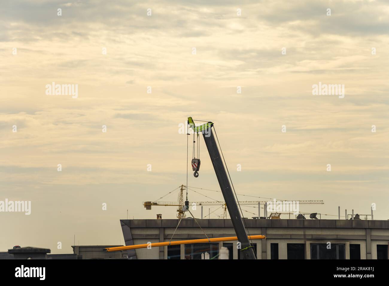 La grue transportant des marchandises vers le haut au lever du soleil. Banque D'Images