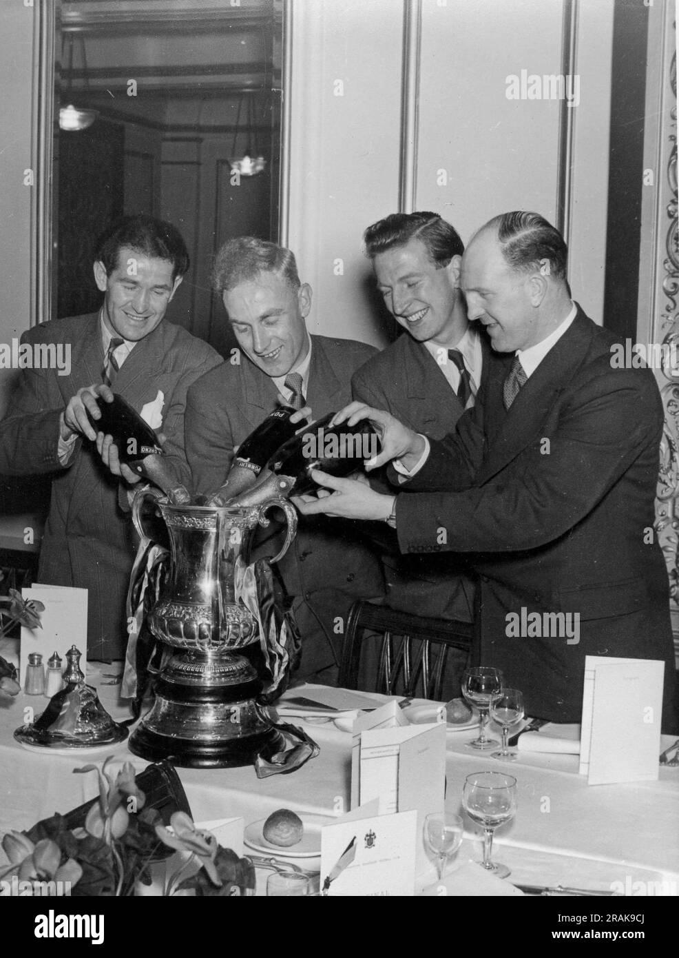 Vainqueurs de la coupe FA Wolverhampton Wanderers versant du champagne dans la coupe FA en 1949 LtoR Jessie Pye, Billy Wright, Sammy Smyth et Stan Cullis Banque D'Images