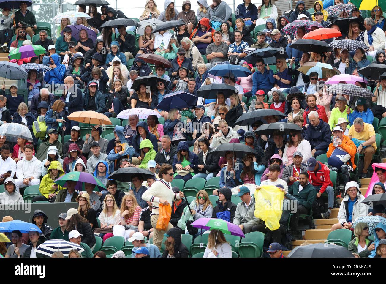 Londres, Royaume-Uni. 04th juillet 2023. Les spectateurs ont mis leurs parapluies pendant que des arrêts de pluie jouent le deuxième jour des championnats de Wimbledon 2023 à Londres, mardi, 04 juillet 2023. Photo de Hugo Philpott/UPI crédit: UPI/Alay Live News Banque D'Images