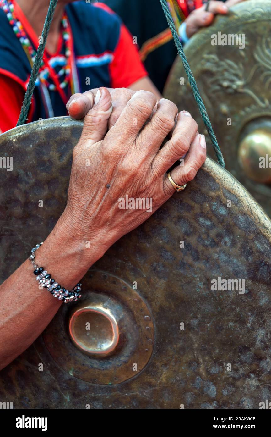 Une femme âgée tenant une main traditionnelle de gong Sabah Malaysia Banque D'Images