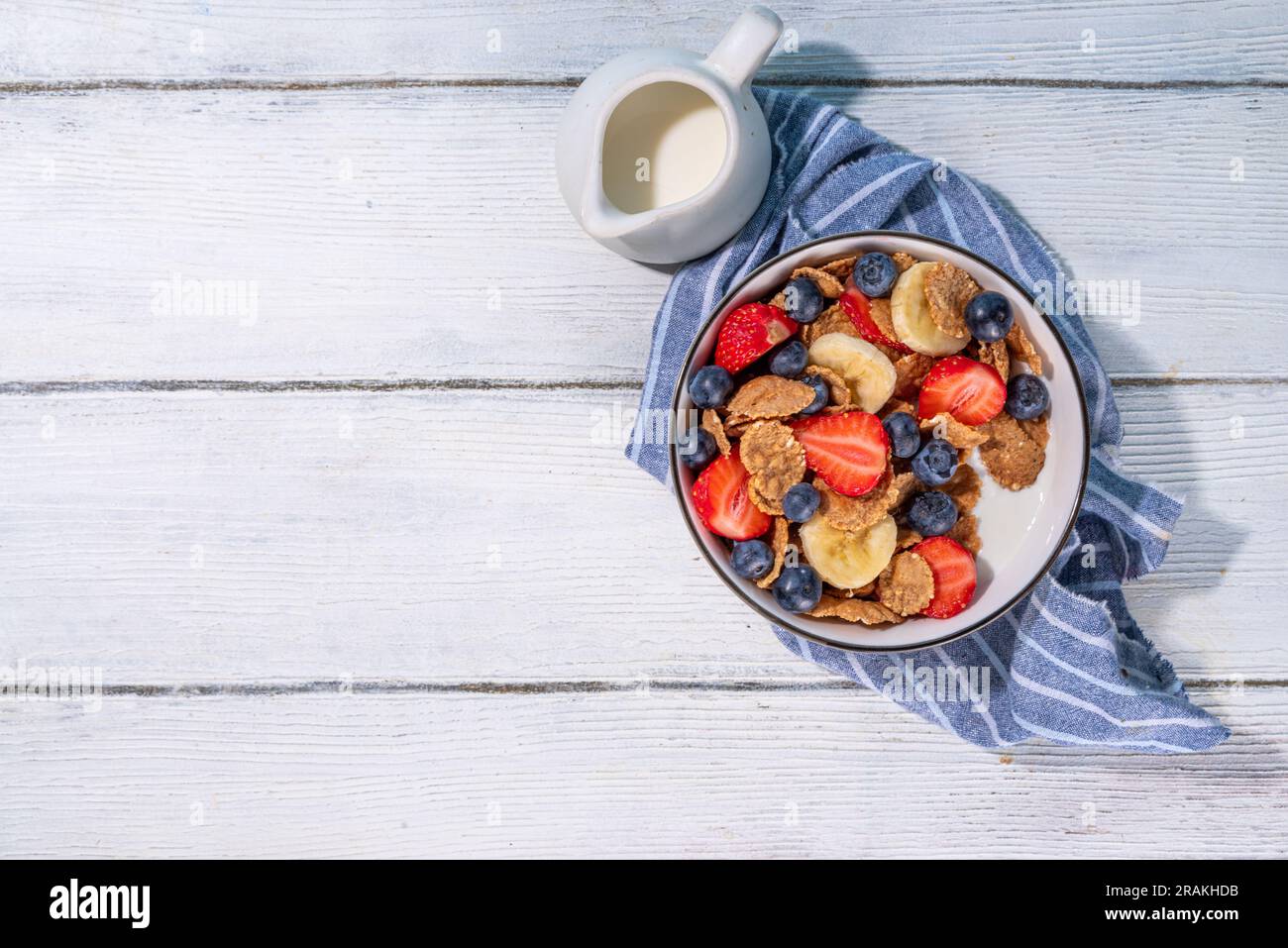 Petit déjeuner d'été diététique vitaminique sain. Céréales flocons multigrains avec yaourt ou lait et fraises, myrtilles, sur l'espace de copie de table de cuisine Banque D'Images