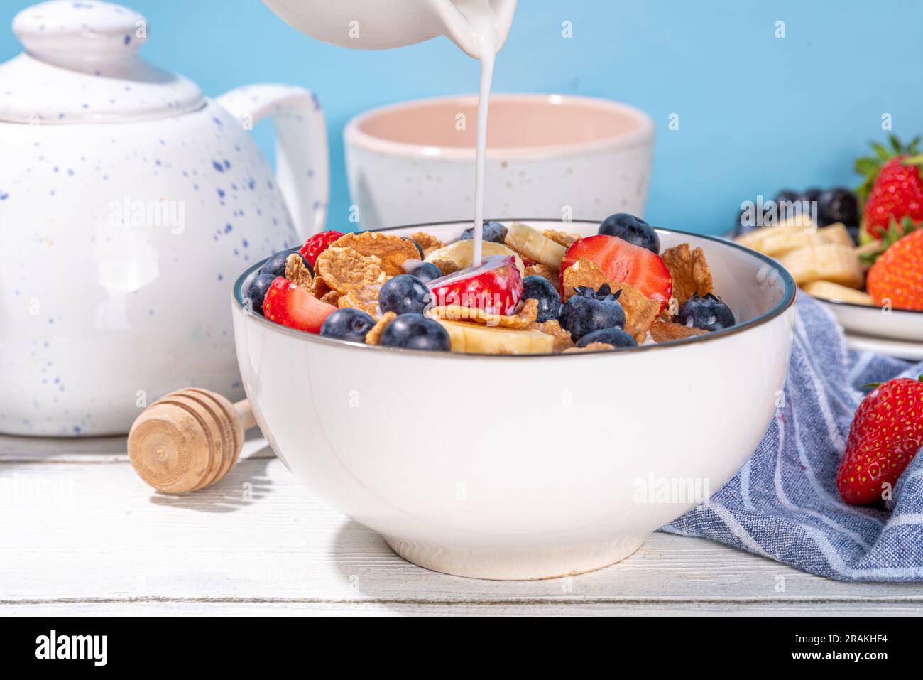 Petit déjeuner d'été diététique vitaminique sain. Céréales flocons multigrains avec yaourt ou lait et fraises, myrtilles, sur l'espace de copie de table de cuisine Banque D'Images
